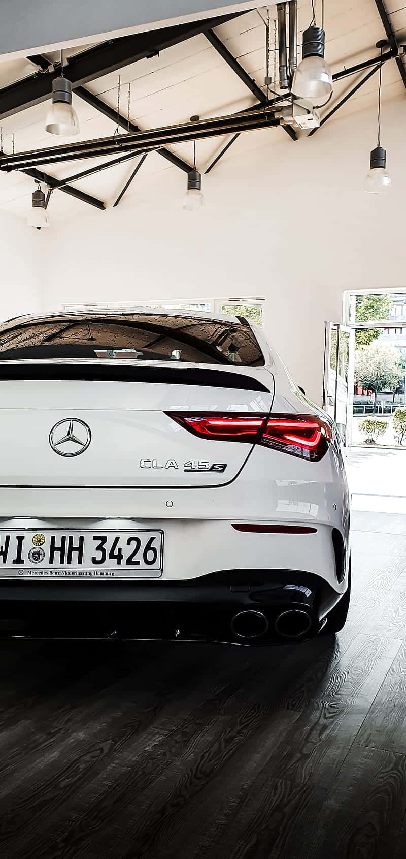Mercedes Benz Cla-class 桌布 壁紙 — 一架時尚的白色 Mercedes-AMG CLA 45 S 停放在室內，工業風吊燈下，深色木地板。