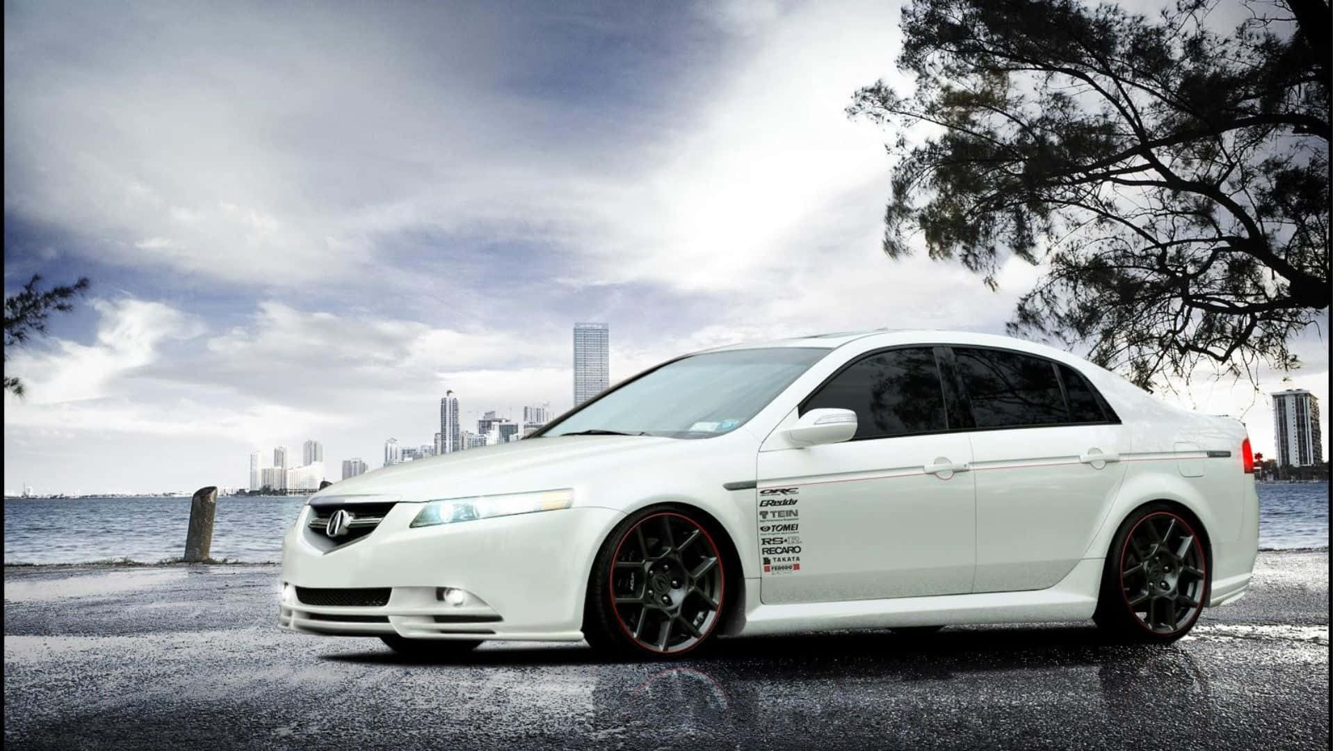 Acura Tl 桌布 壁紙 — 一架時尚的白色改裝轎車配黑色輪圈，停泊在潮濕的海岸道路上，天空多雲，背景是城市天際線。