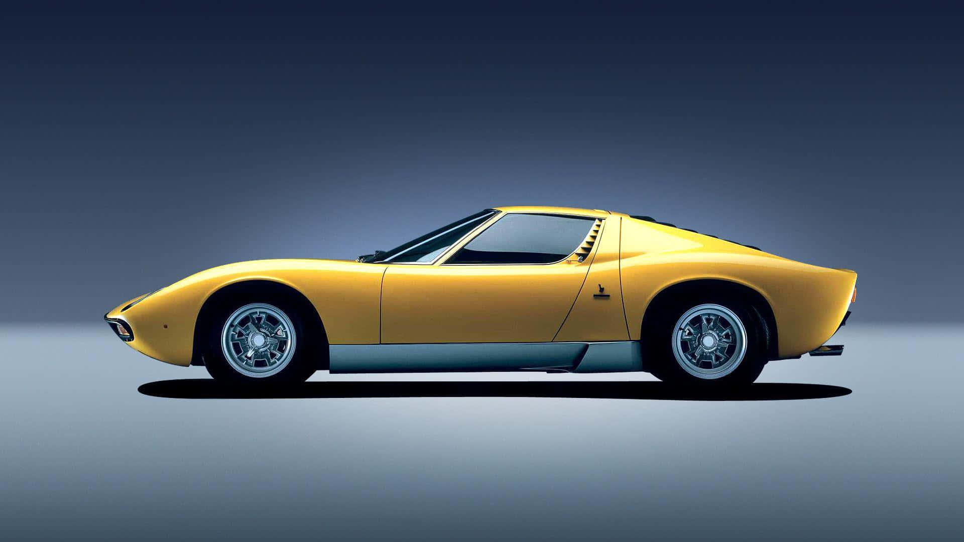 Lamborghini Miura 桌布 壁紙 — 一輛時尚的黃色經典跑車配銀色輪圈，側面展示在漸變灰色工作室背景前。