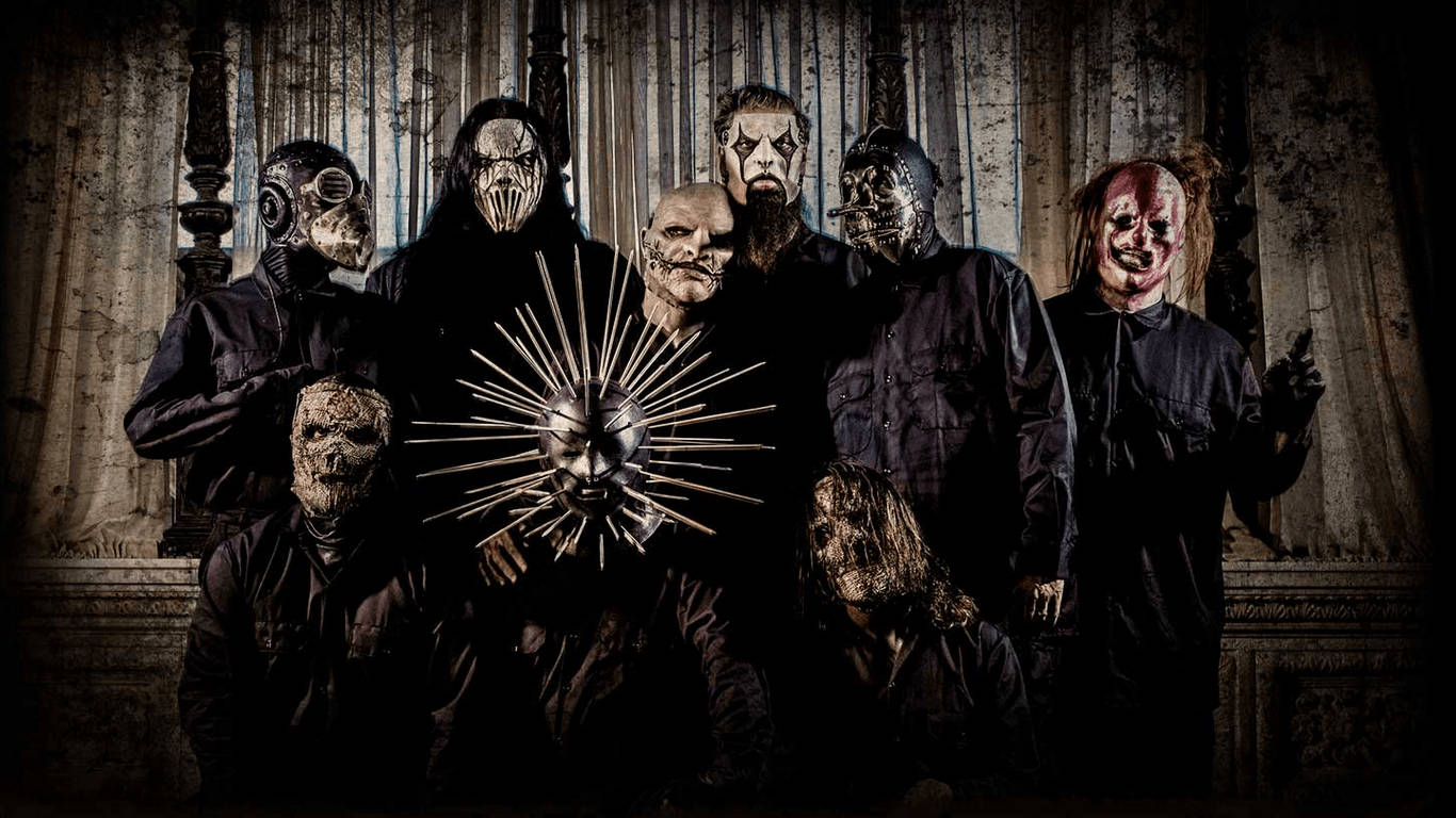 Slipknot《The Gray Chapter》專輯封面壁紙 壁紙 — 七個戴面具、身穿深色衣服的人物站在一個哥德式大廳中，大廳有華麗的柱子和戲劇性的燈光。