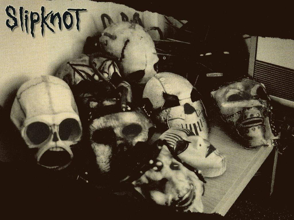 Slipknot 名稱與面具收藏 壁紙 — Slipknot 標誌性的怪誕面具堆疊在一起的黑白照片。