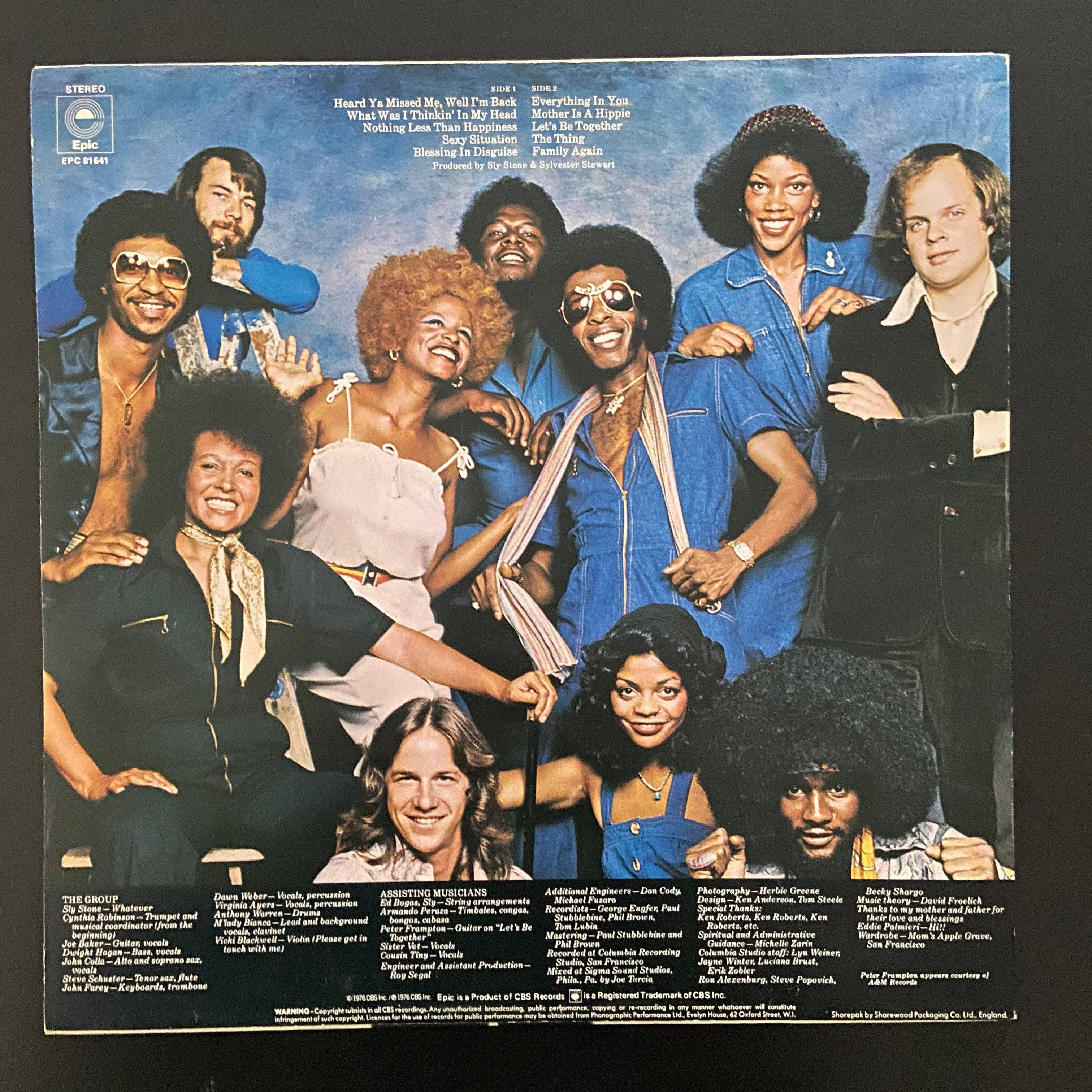 Sly 及 The Family Stone 派對攝影 壁紙 — 一張充滿活力的1970年代照片，The Stylistics 組合穿著大膽的藍白服裝，在純藍色背景前一起擺姿勢。