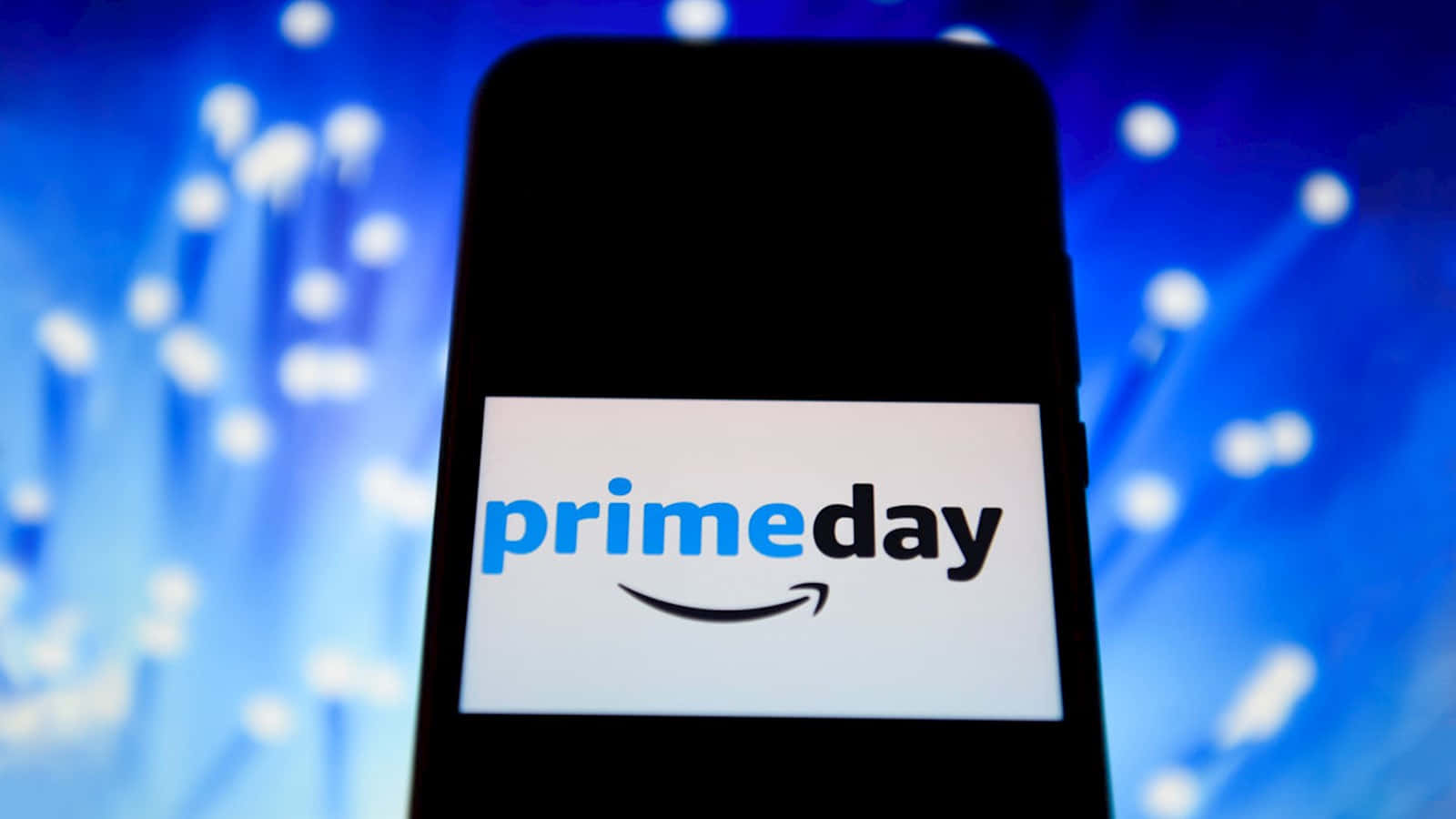  壁紙 — 智能手機在充滿活力的藍色散景背景上顯示Prime Day標誌，並帶有發光的燈光條紋。