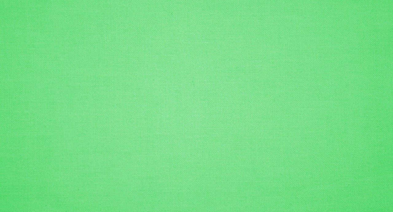 Green Solid Color 桌布 壁紙 — 平滑的純綠色布料紋理，帶有微妙的編織圖案和均勻的照明。