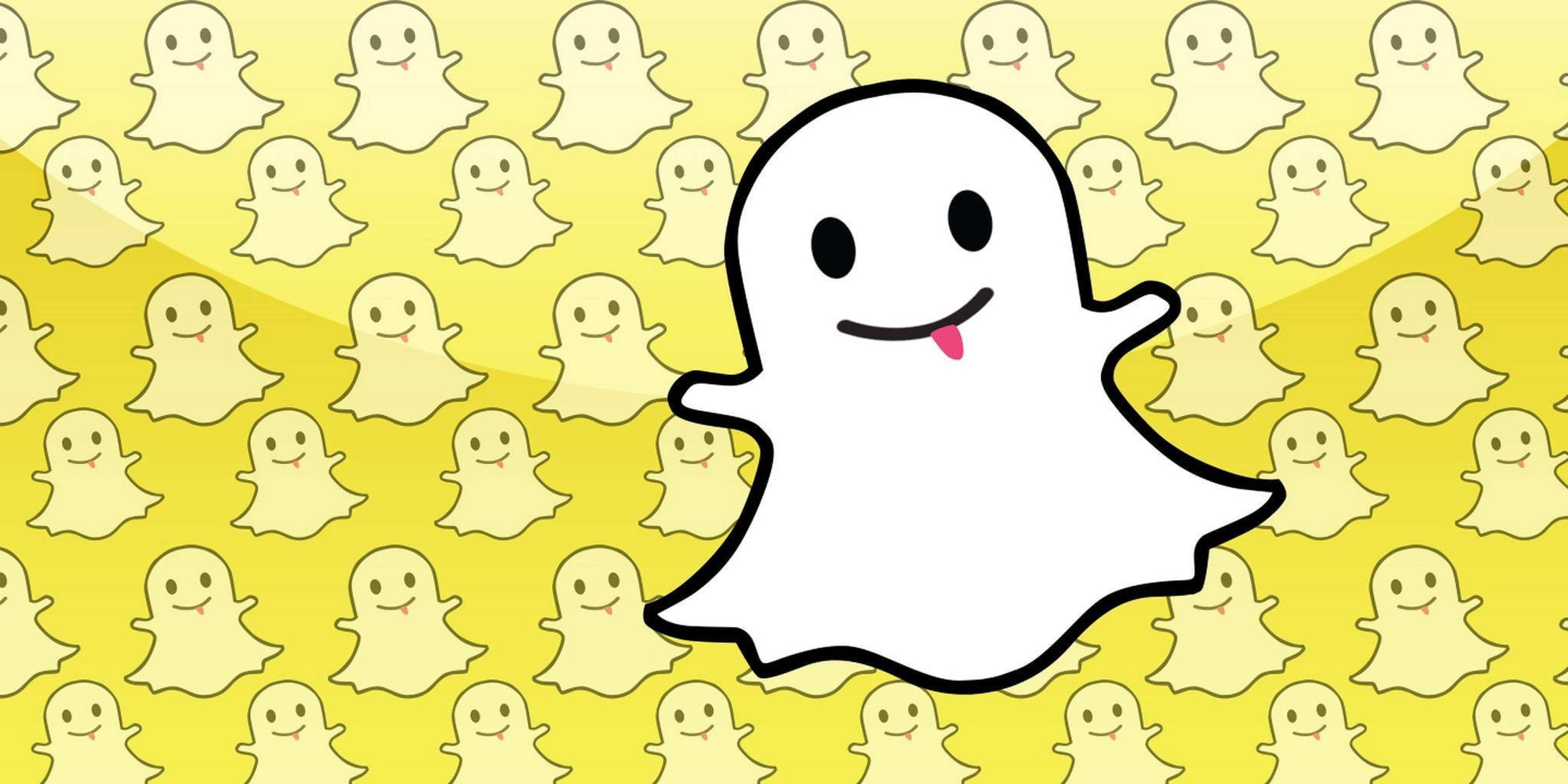 Snapchat卡通幽靈圖案 壁紙 — 一個開心嘅白色卡通鬼魂，伸出粉紅色嘅脷，喺充滿細小微笑鬼魂嘅黃色背景上頑皮地展示。