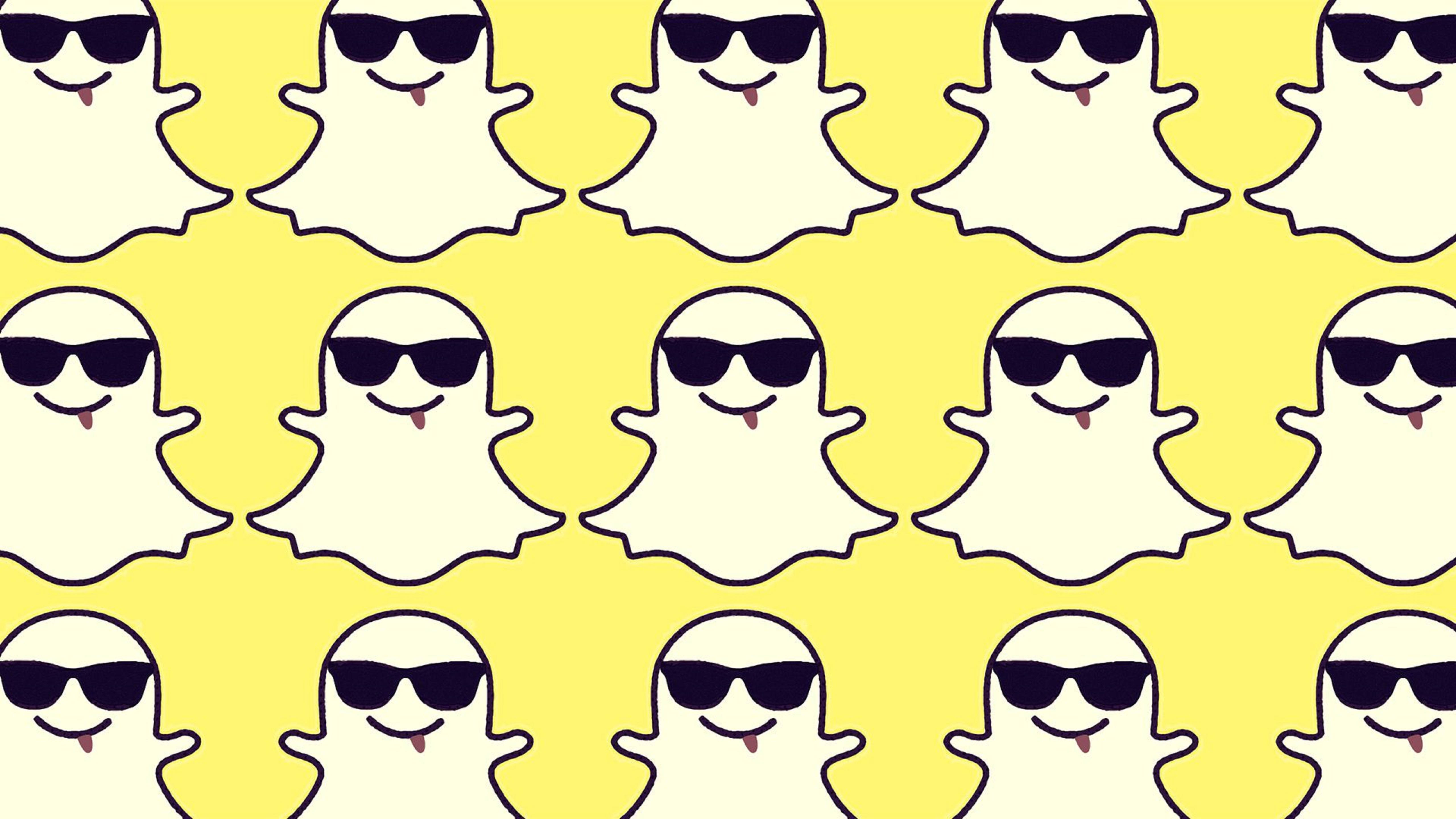 Snapchat可愛幽靈圖案 壁紙 — 在明亮的黃色背景上重複出現的卡通鬼魂，戴著黑色太陽眼鏡和粉紅色舌頭。