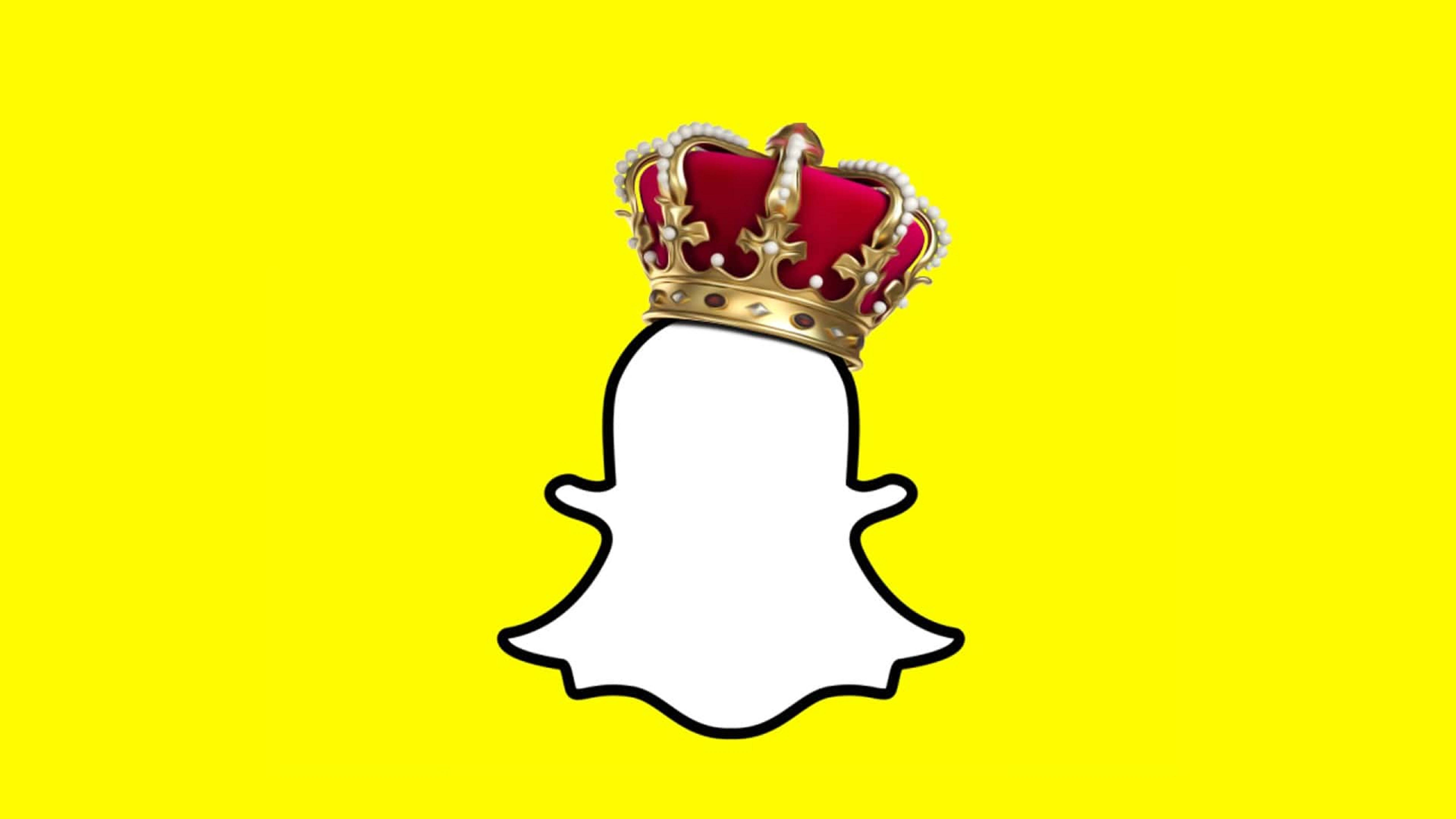 Snapchat王冠標誌藝術 壁紙 — 一個白色Snapchat鬼魂標誌，戴著紅色天鵝絨和金色皇冠，背景為亮黃色。