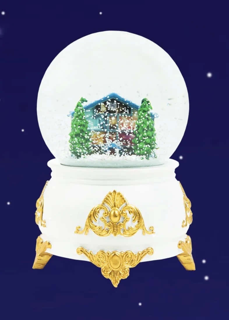  壁紙 — 一個雪球，裏面有雪景小木屋和松樹，放置在一個華麗的白色和金色底座上，背景是繁星點點的夜空。