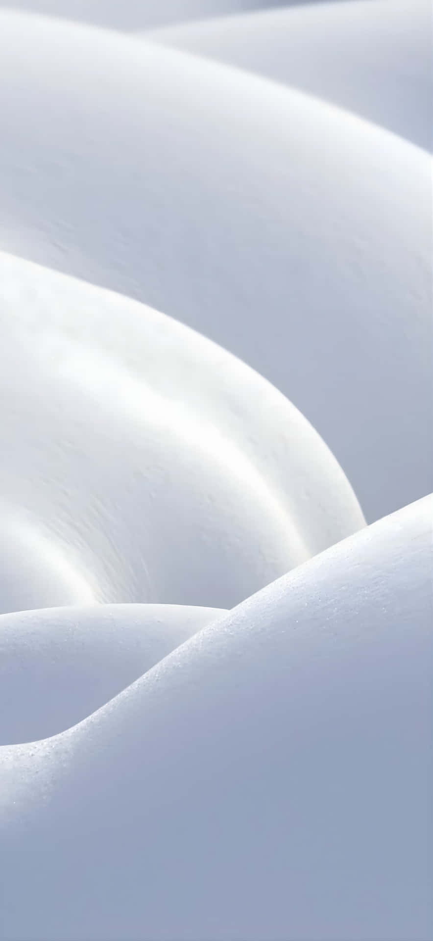  壁紙 — 柔軟起伏的雪堆捕捉柔和光線，在寧靜的冬日場景中營造出平靜的曲線和微妙的陰影。