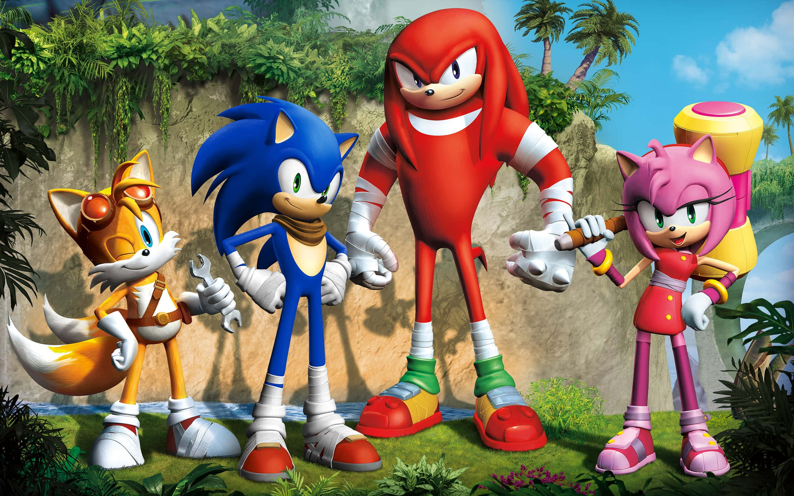 Sonic The Hedgehog Characters 桌布 壁紙 — Sonic、Knuckles、Amy 和 Tails 一起站在一個茂密的叢林環境中，背景有棕櫚樹和岩石懸崖。