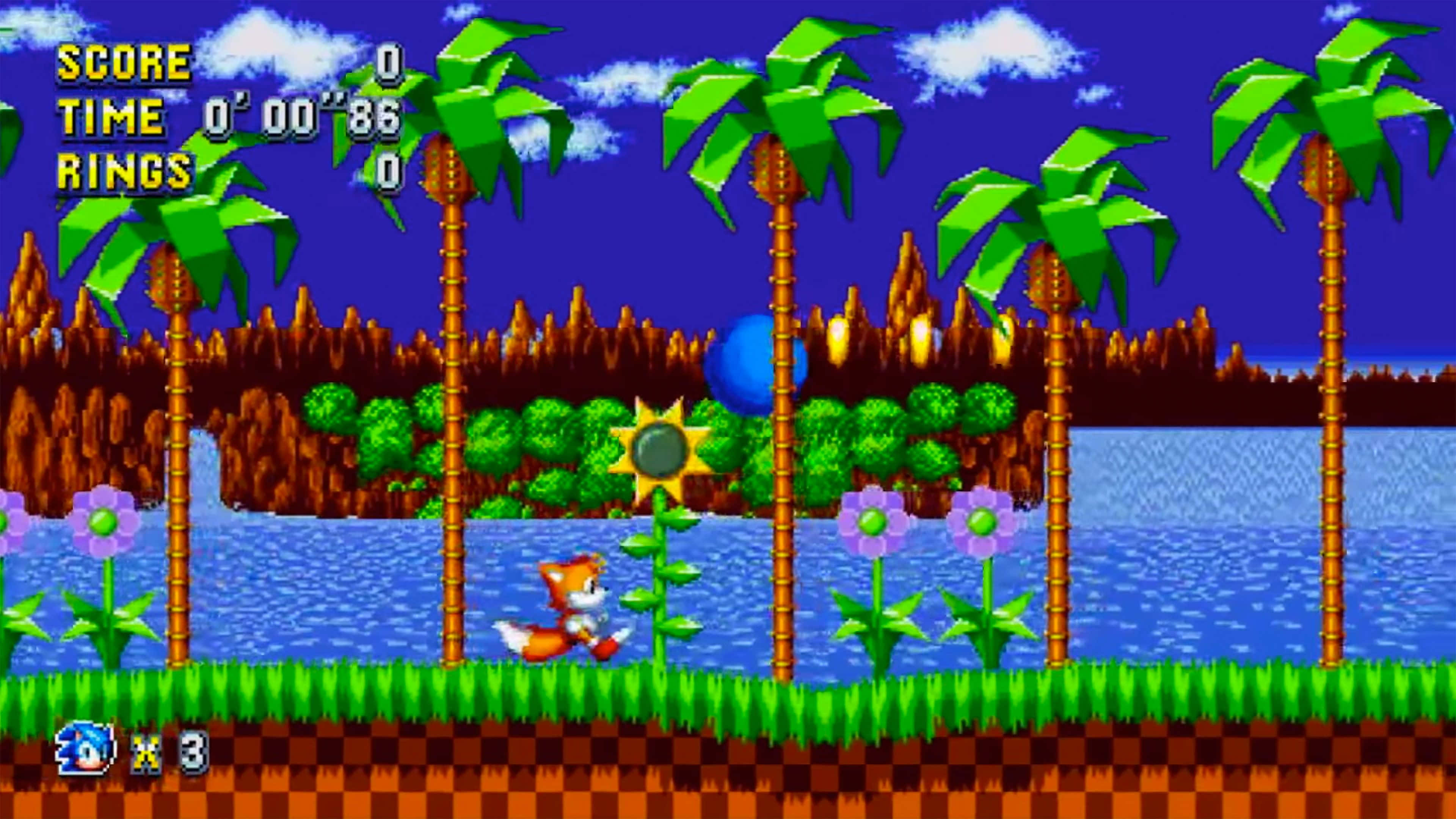 Sonic Angel Island 桌布 壁紙 — Sonic the Hedgehog 喺陽光普照嘅天空下，穿過一個充滿活力嘅像素化叢林關卡，有棕櫚樹同藍色水。