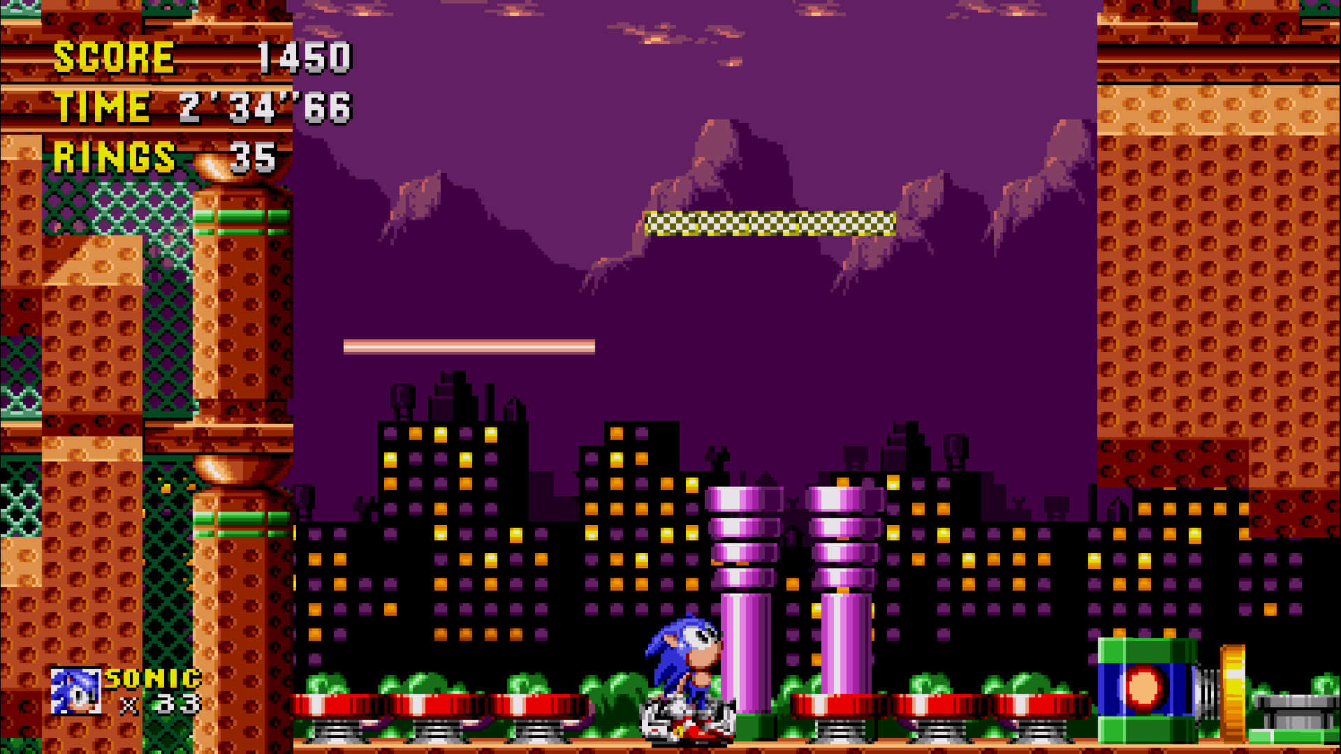 Sonic Spring Yard Zone 桌布 壁紙 — Sonic the Hedgehog 在像素化的夜間城市景觀中奔跑，建築物發光，天空呈紫色。