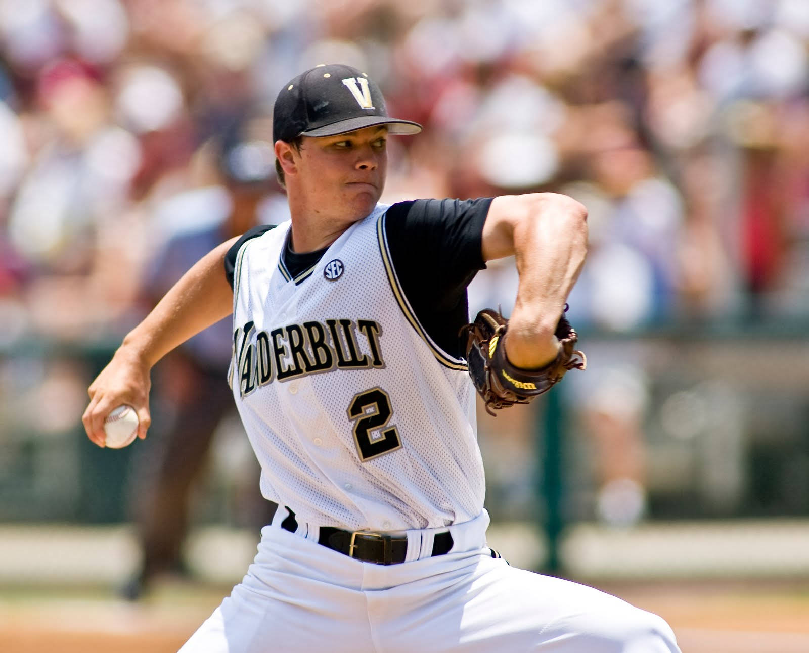 Sonny Gray 在棒球賽中展現實力 壁紙 — 范德比爾特棒球投手在日間比賽中專注投球，背景有模糊的觀眾。