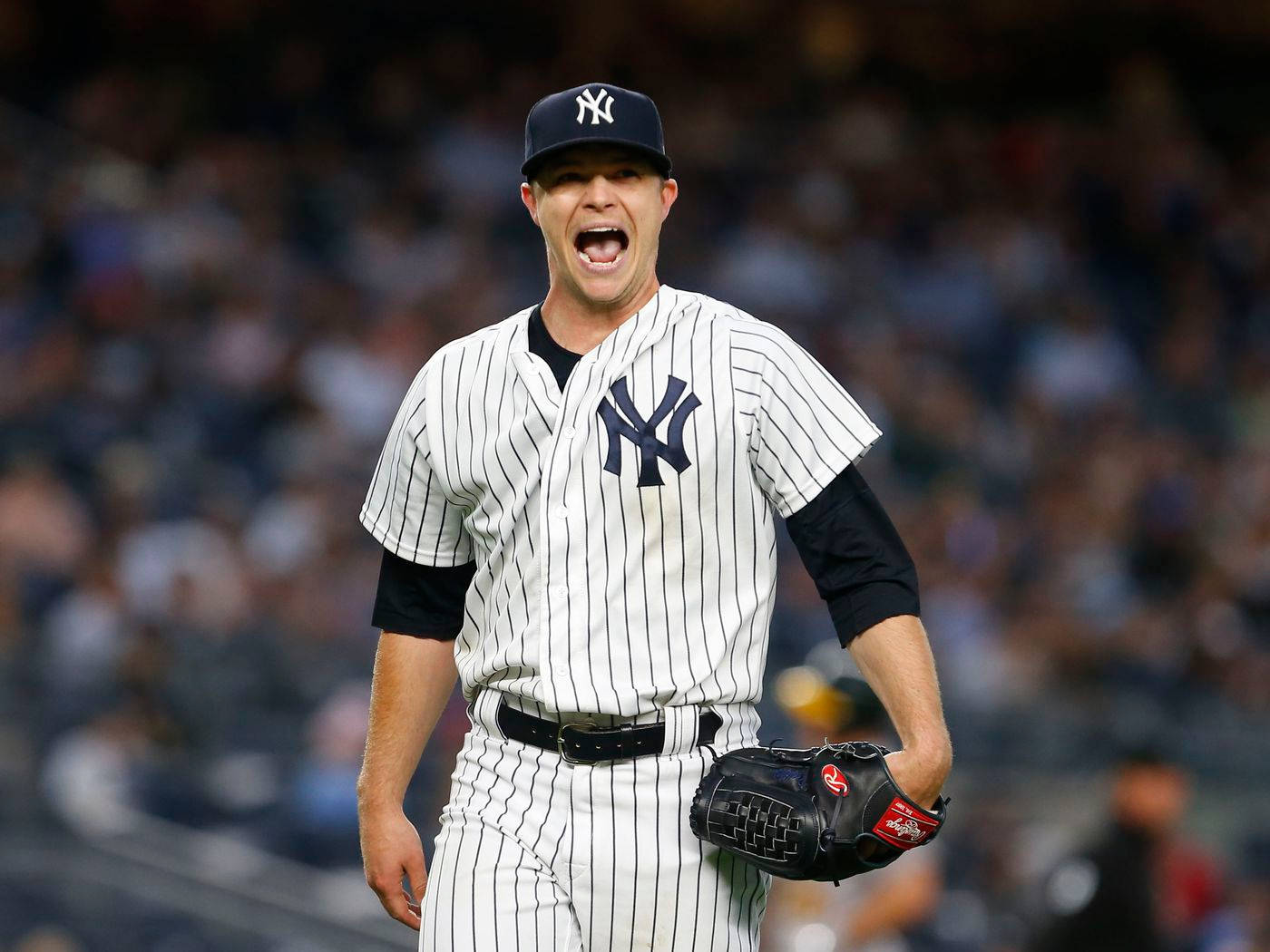 Sonny Gray 領喊 壁紙 — 一名身穿細條紋球衣的紐約洋基棒球選手在夜間比賽中，在球場燈光下激情吶喊。