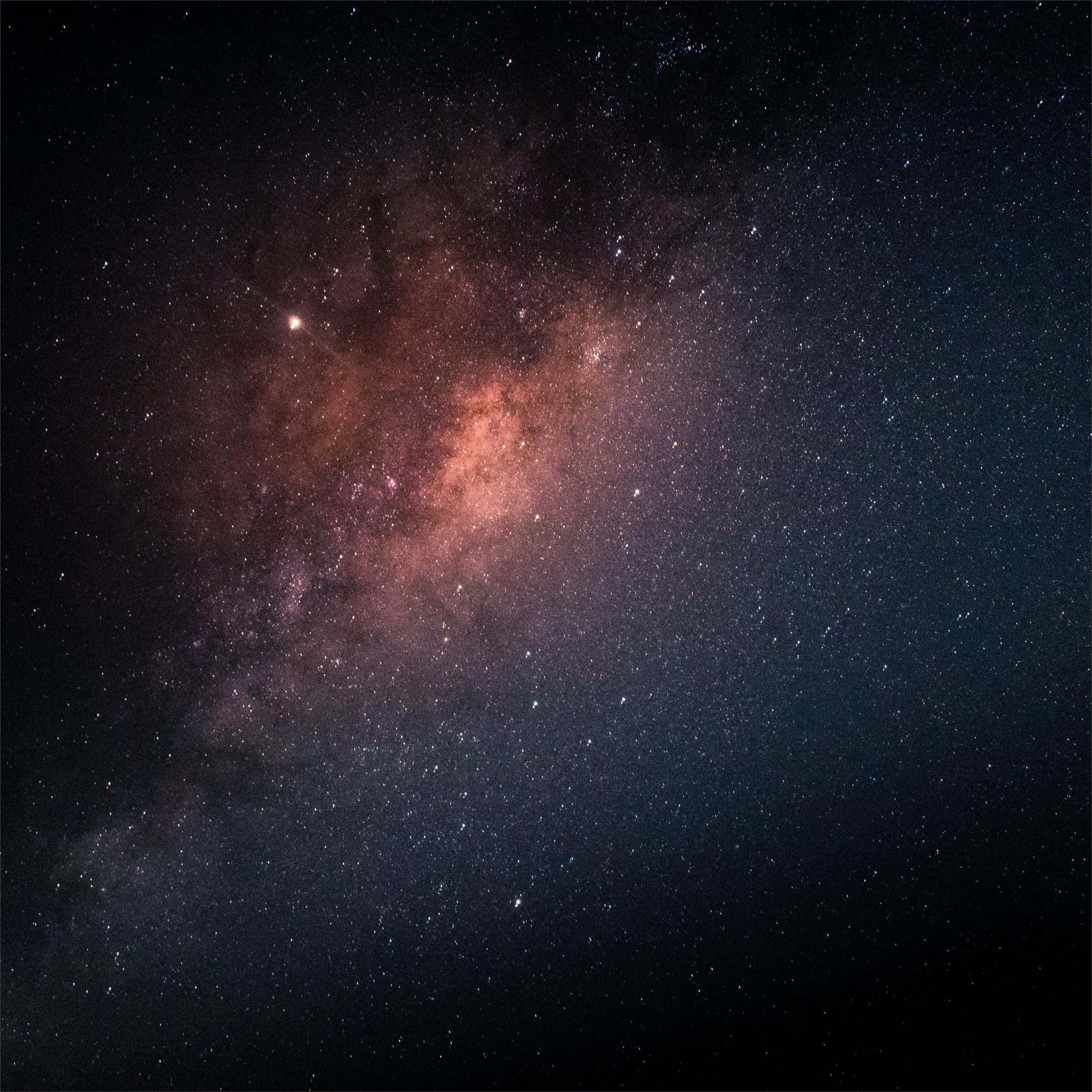 以最新Space iPad提升創意 壁紙 — 令人嘆為觀止的銀河系景觀，在繁星點點的夜空中閃耀著粉紅色和紫色的星雲。