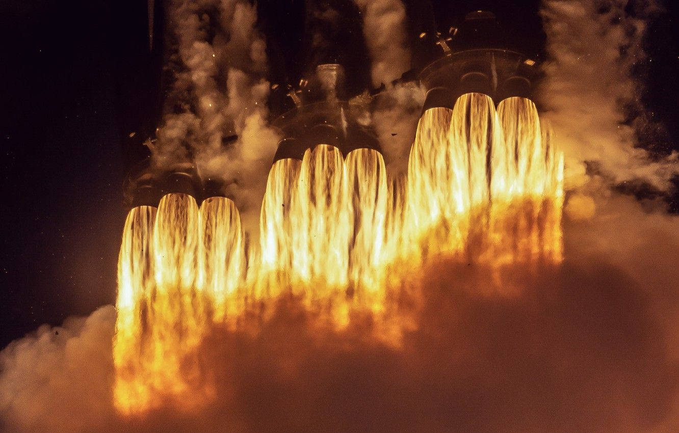 火箭引擎在夜間噴射出明亮的橙色火焰和濃煙。 — Spacex GIF 壁紙