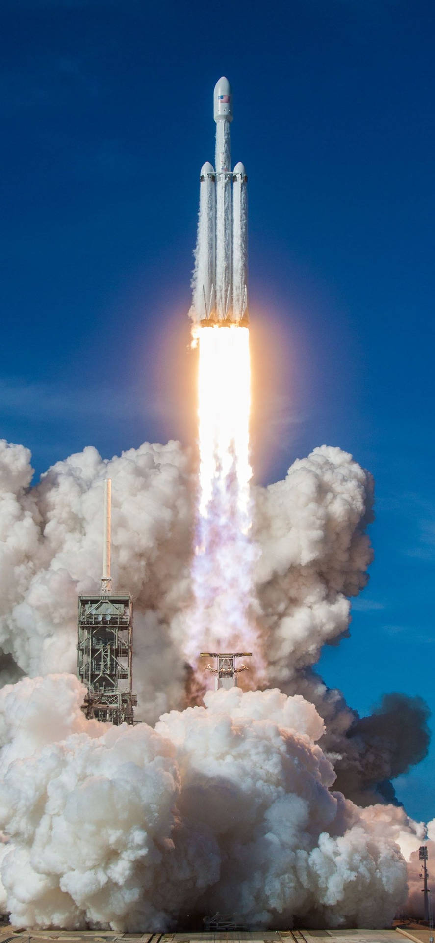 火箭發射，明亮的火焰和濃煙映襯著藍天。 — Spacex GIF 壁紙