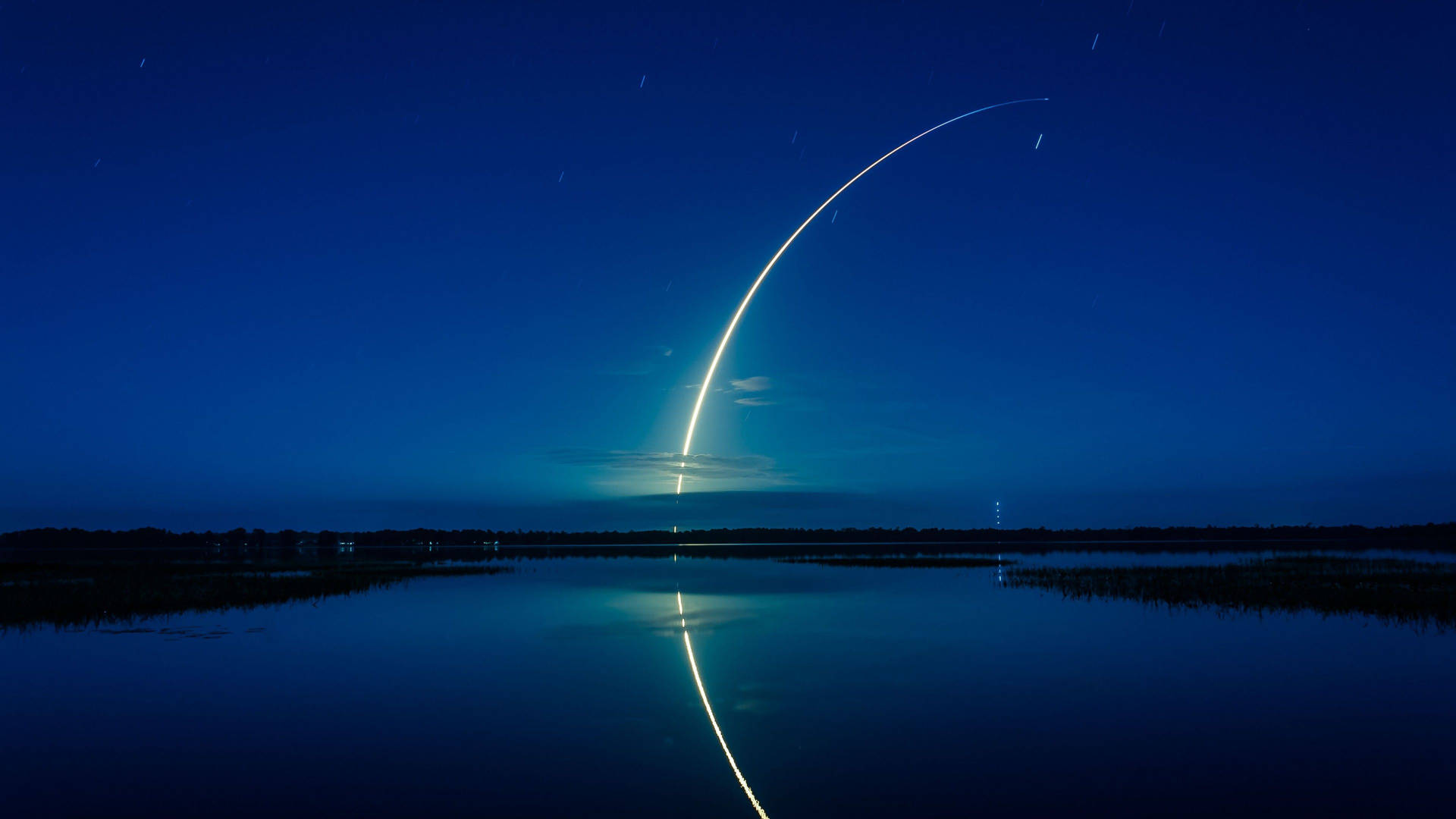 星空下平靜水面反射的夜間火箭發射 — Spacex GIF 壁紙
