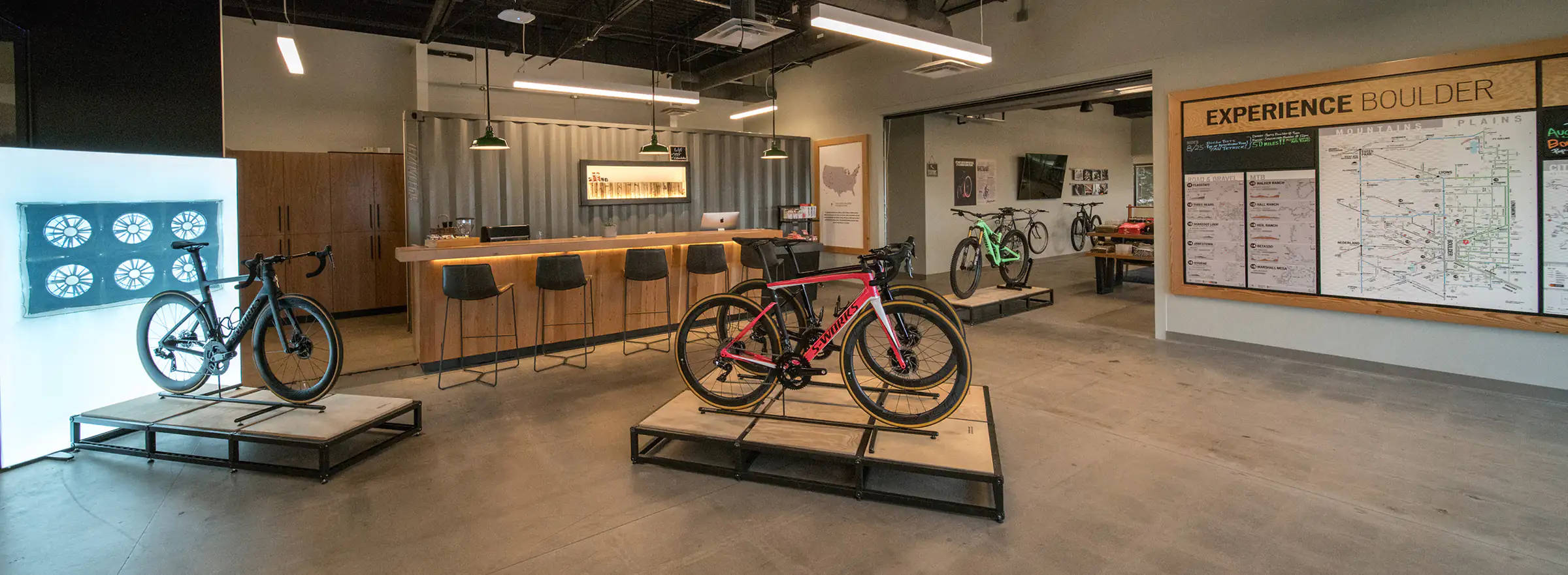 Specialized 自行車展示 壁紙 — 現代單車店內部，陳列架上擺放時尚單車，上方有明亮的吊燈。