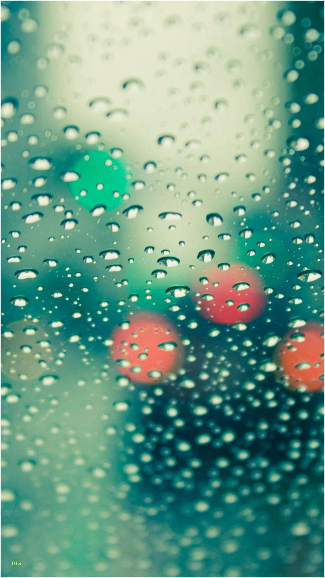 玻璃上的雨滴，模糊的城市燈光閃爍著紅色和綠色。