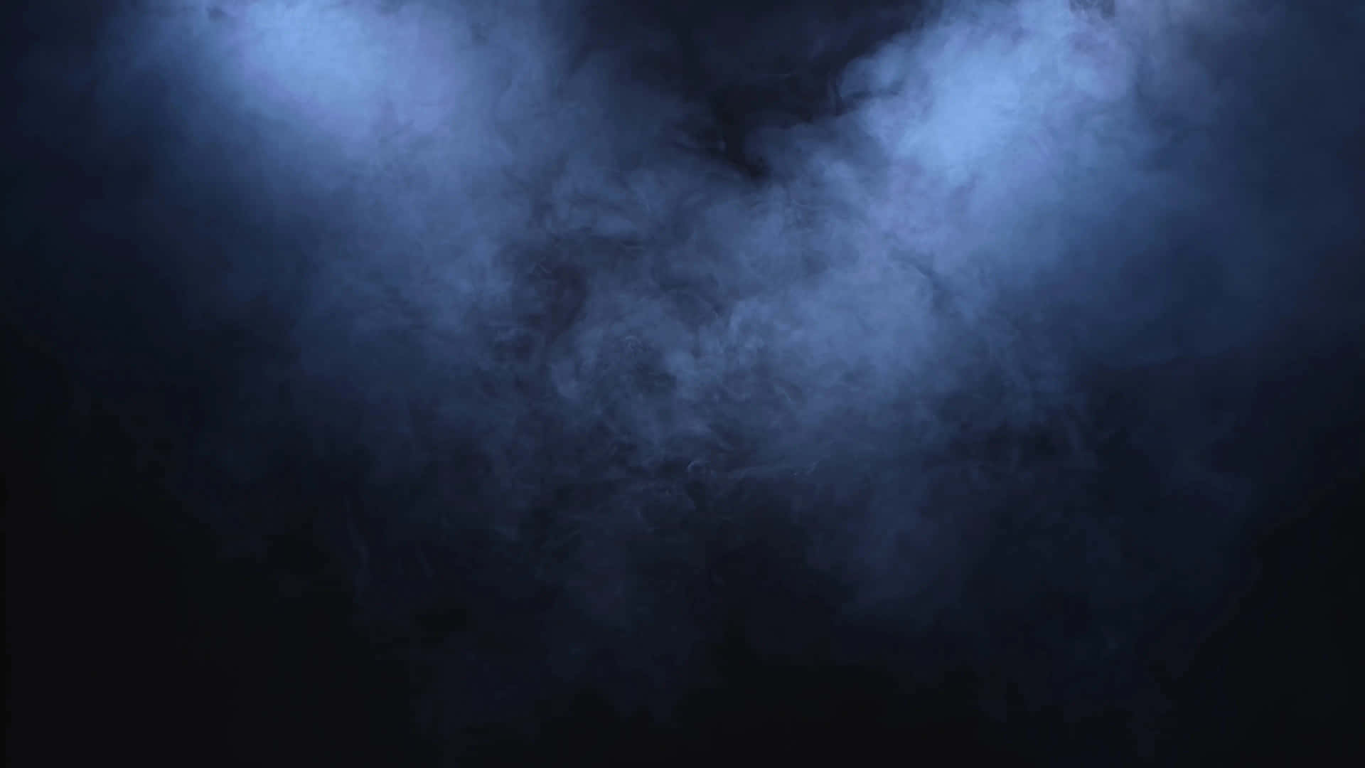 藍色煙霧在黑暗中於聚光燈下旋轉，營造戲劇效果。