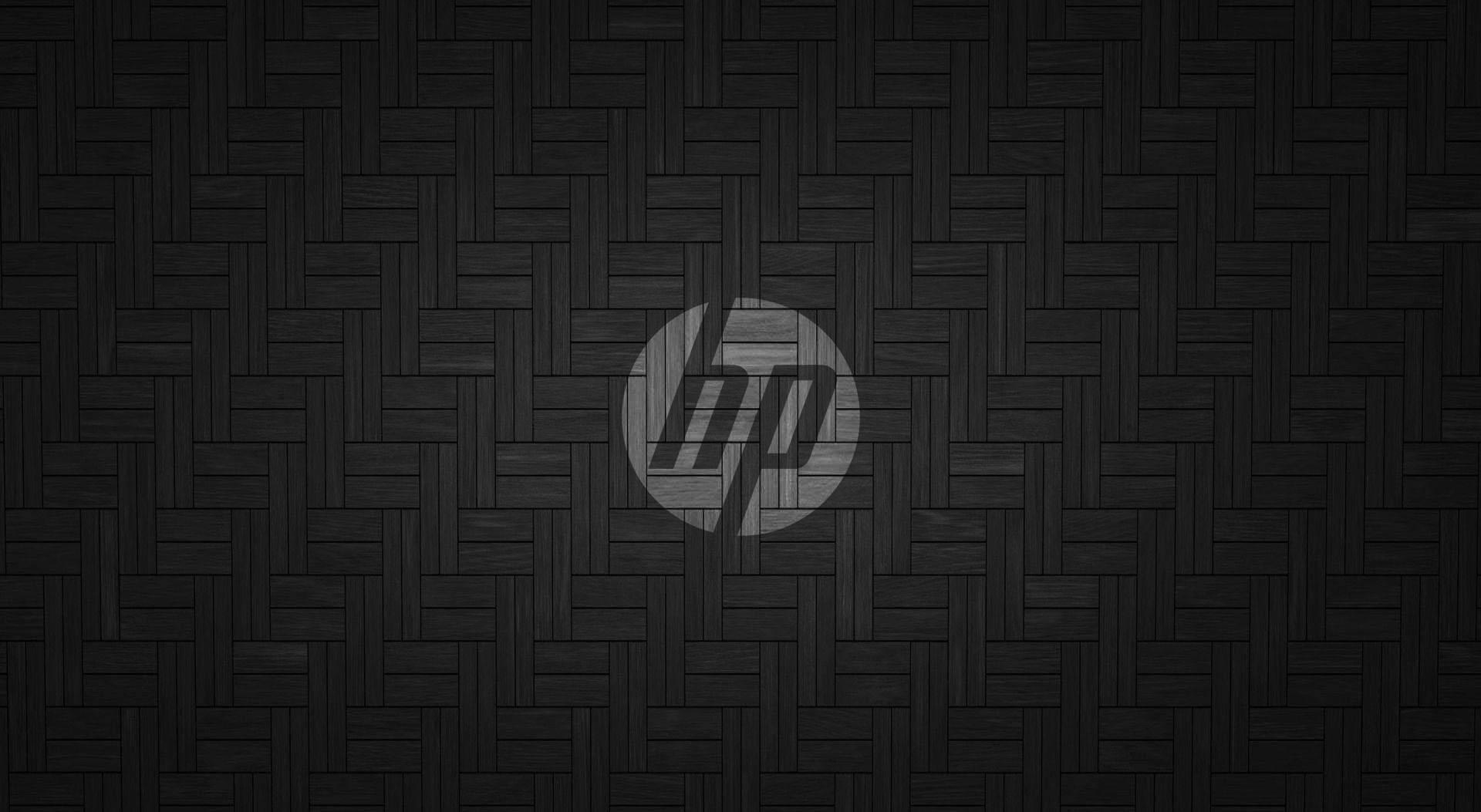 Spotlight HP Laptop Logo 壁紙 — 深色編織紋理牆紙，黑色背景中央有灰色HP標誌。