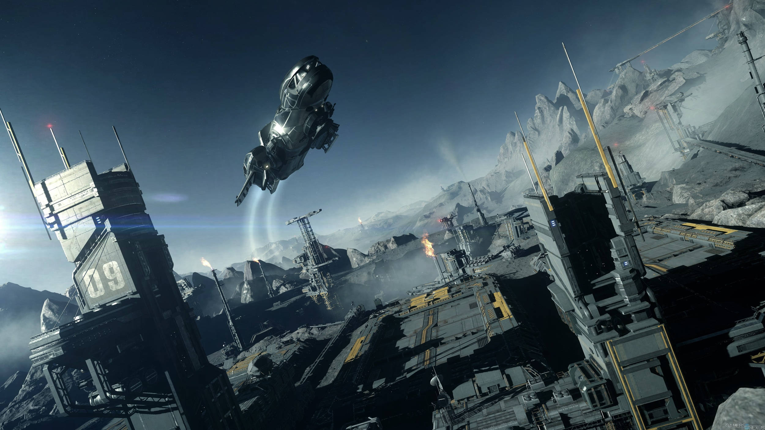 Star Citizen 模擬遊戲截圖 壁紙 — 一艘時尚的未來太空船盤旋在荒涼的工業城市景觀上空，周圍有鋸齒狀的山脈和發光的建築，背景是暮色天空。