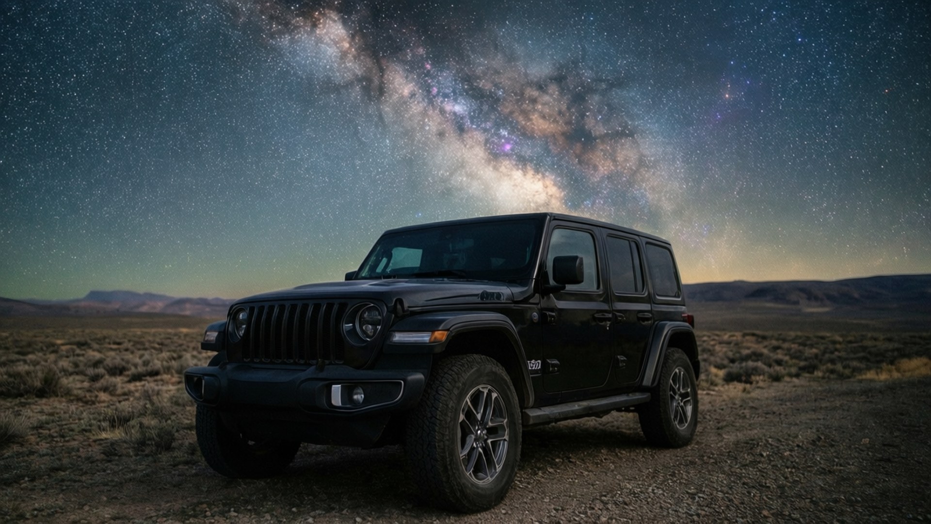 黑色Jeep Wrangler夜間停在沙漠中，銀河高懸