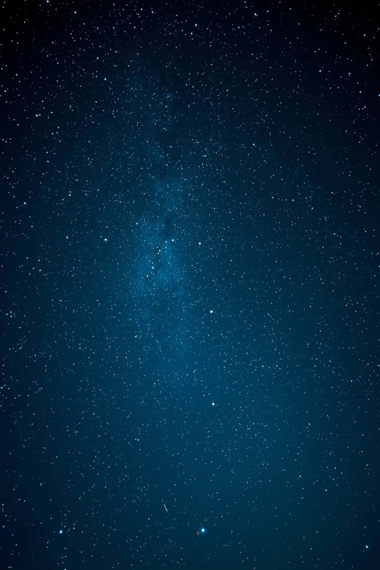 星空之夜，銀河系在深藍色調中垂直發光。