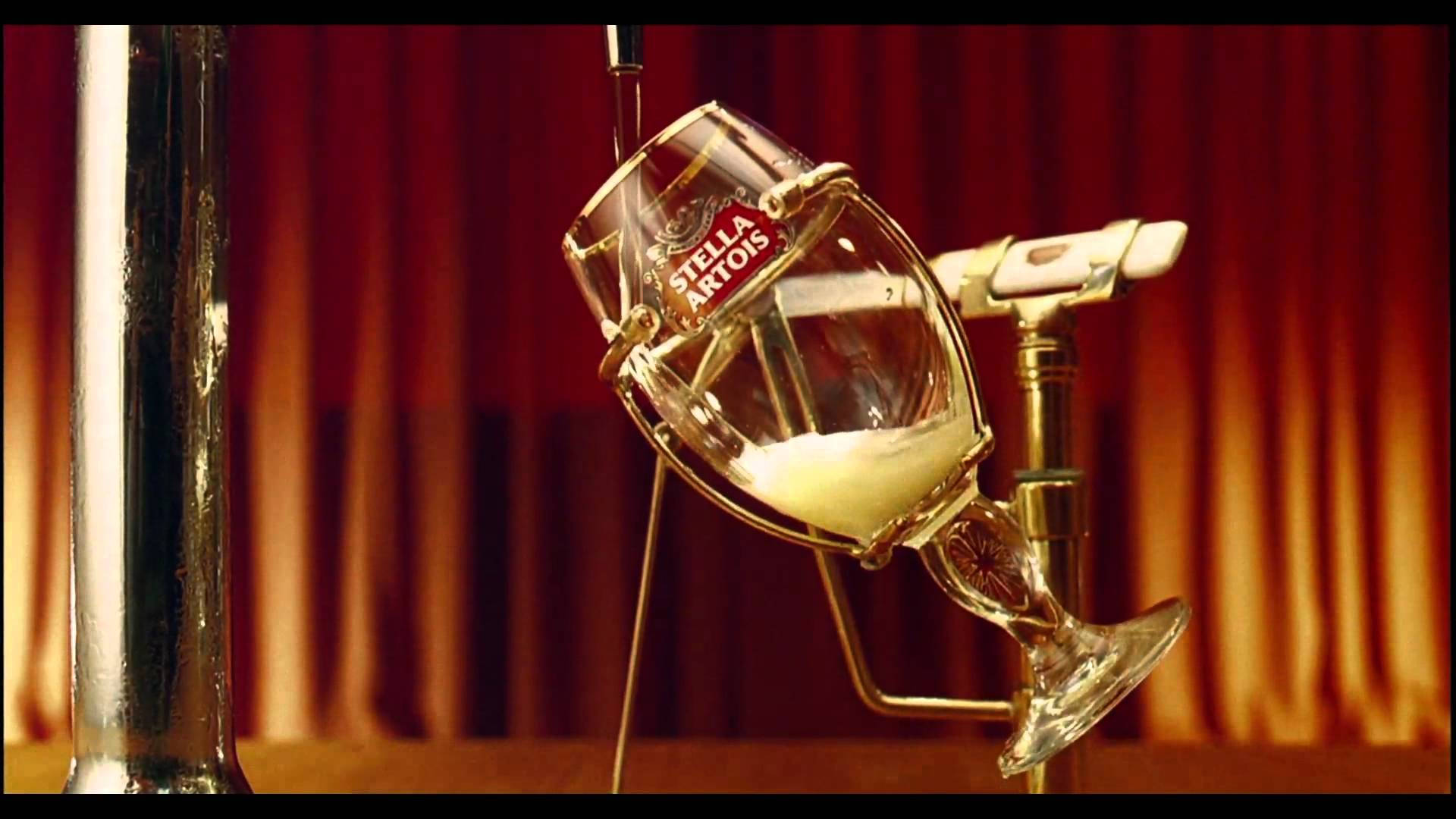 Stella Artois 啤酒杯在後面有紅色窗簾的酒吧中被裝滿。