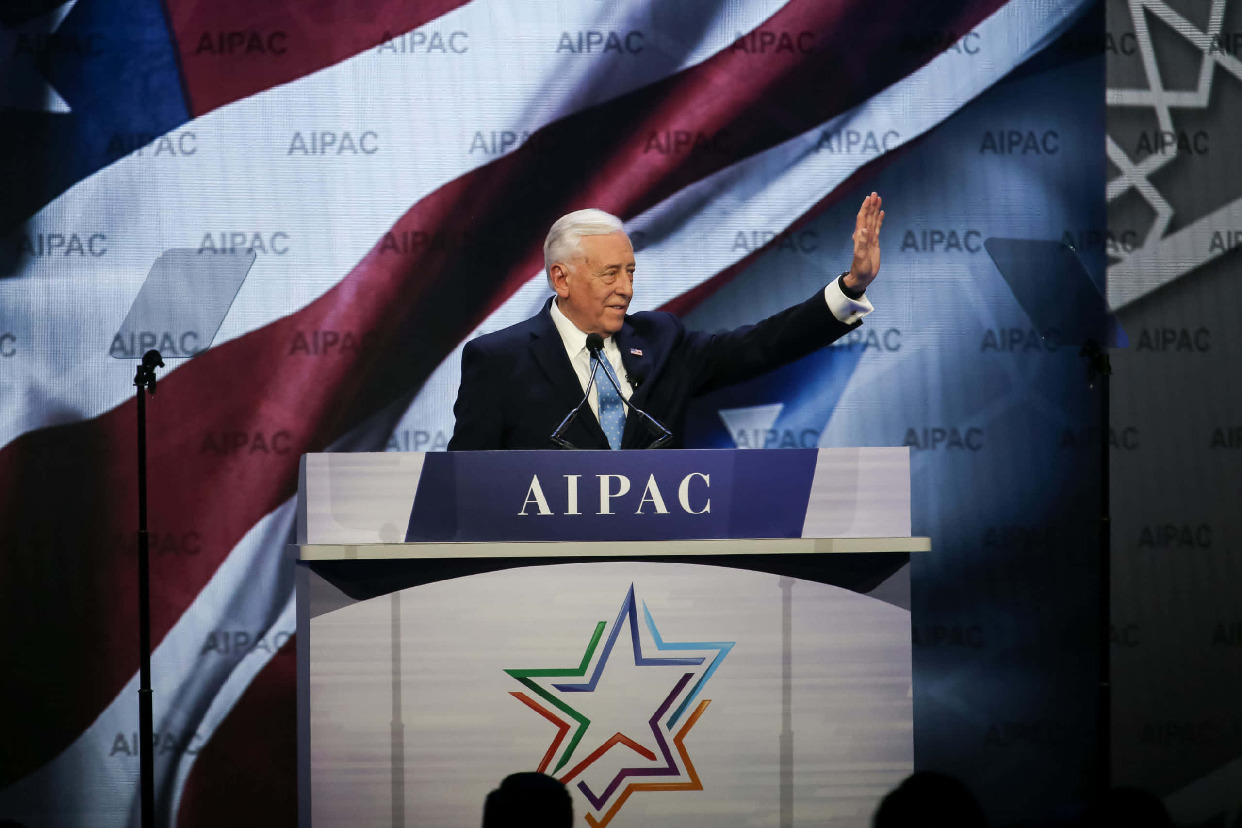 Steny Hoyer 出席 AIPAC 會議 壁紙 — 前總統喬·拜登在AIPAC講台上發表演說，向觀眾揮手，背景是大型美國國旗。