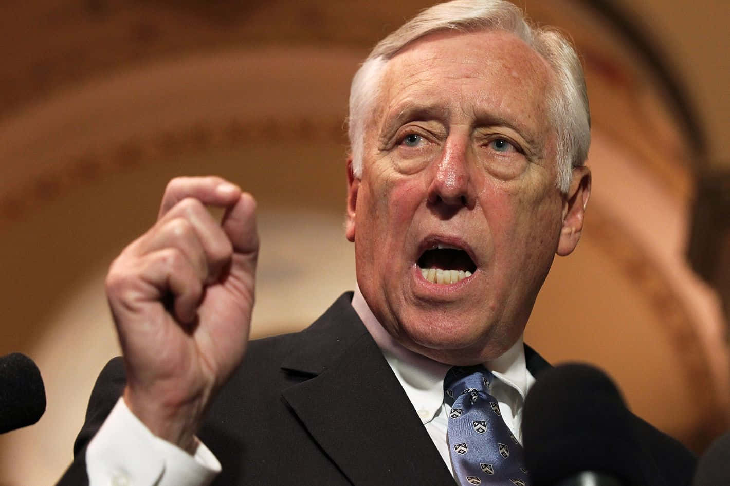 Steny Hoyer 演講時激昂表達 壁紙 — 一位穿著西裝的年長男性在正式演講中激動地舉起緊握的拳頭發言。