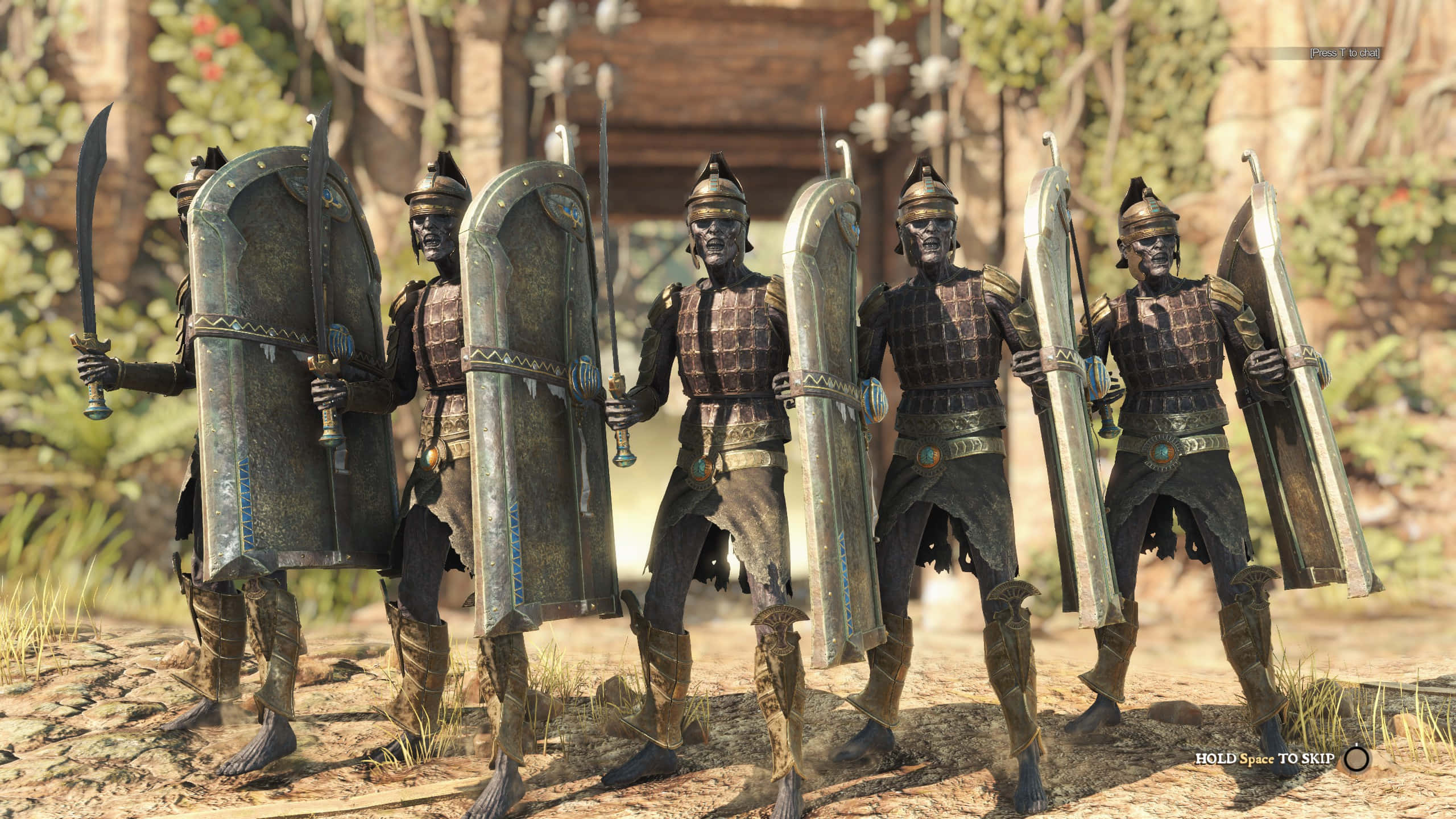 《Strange Brigade》的迷人世界 壁紙 — 五名身穿古代盔甲的裝甲戰士在陽光明媚的森林空地中排成一排，手持盾牌和劍。