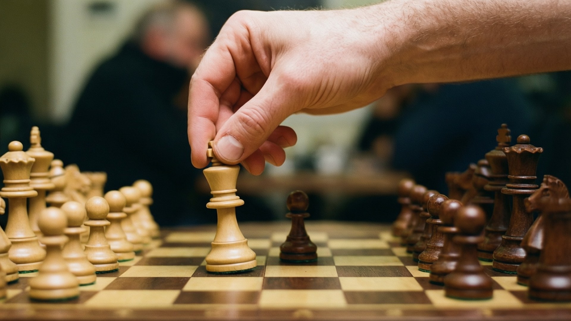在木製棋盤上下棋時，一隻手拿起一個國際象棋兵。