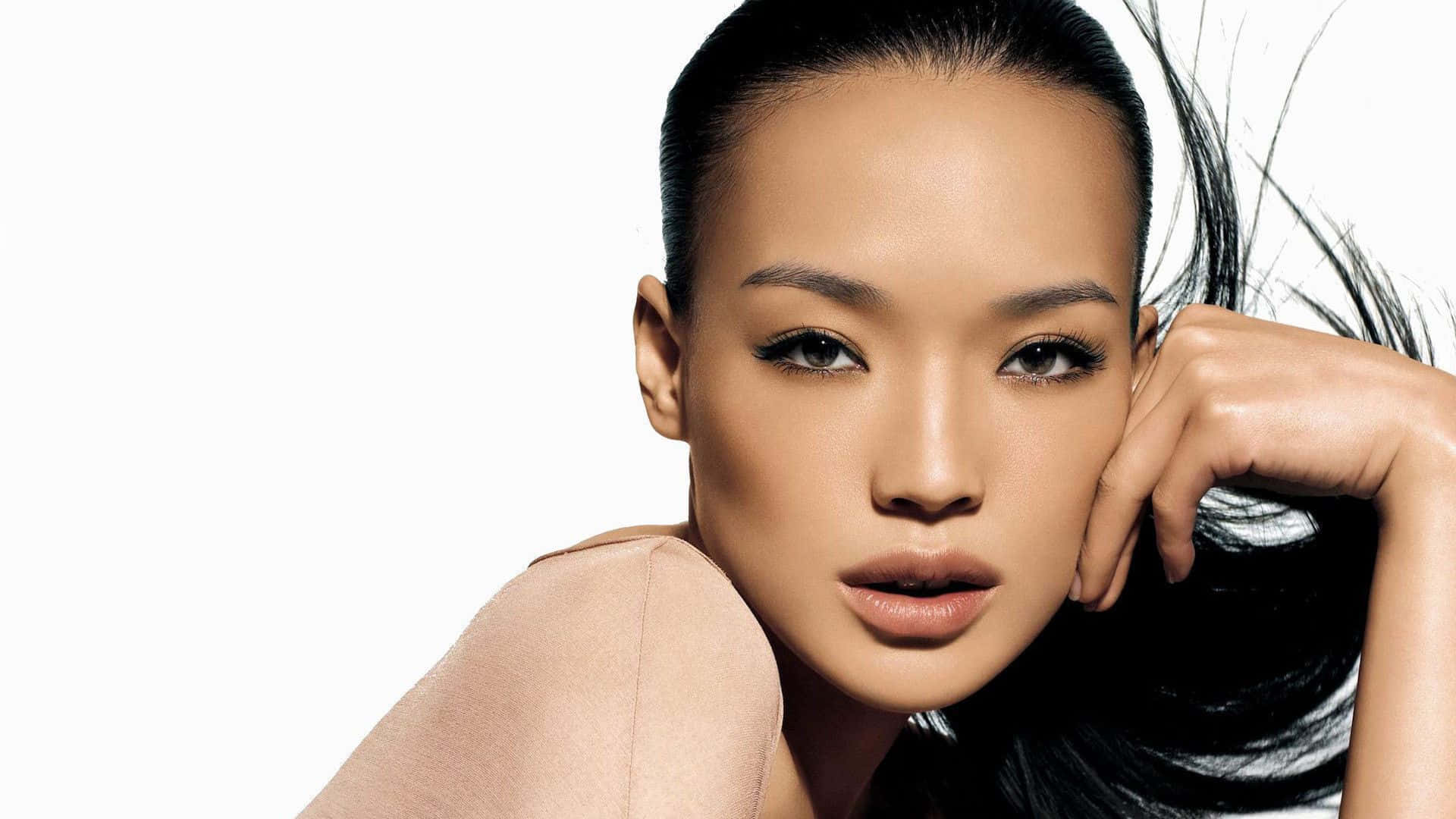 Shu Qi 桌布 壁紙 — 一個引人注目的肖像，一位擁有光滑黑髮和大膽妝容的女性，背景為純白色。