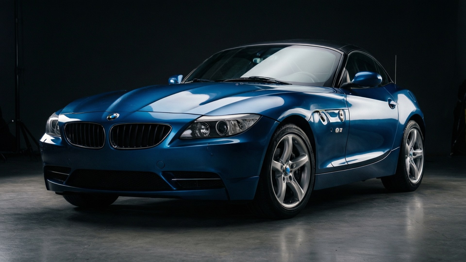 Studio Elegance 壁紙 — 一輛時尚的藍色BMW Z4敞篷跑車在暗色背景的攝影棚燈光下閃耀。