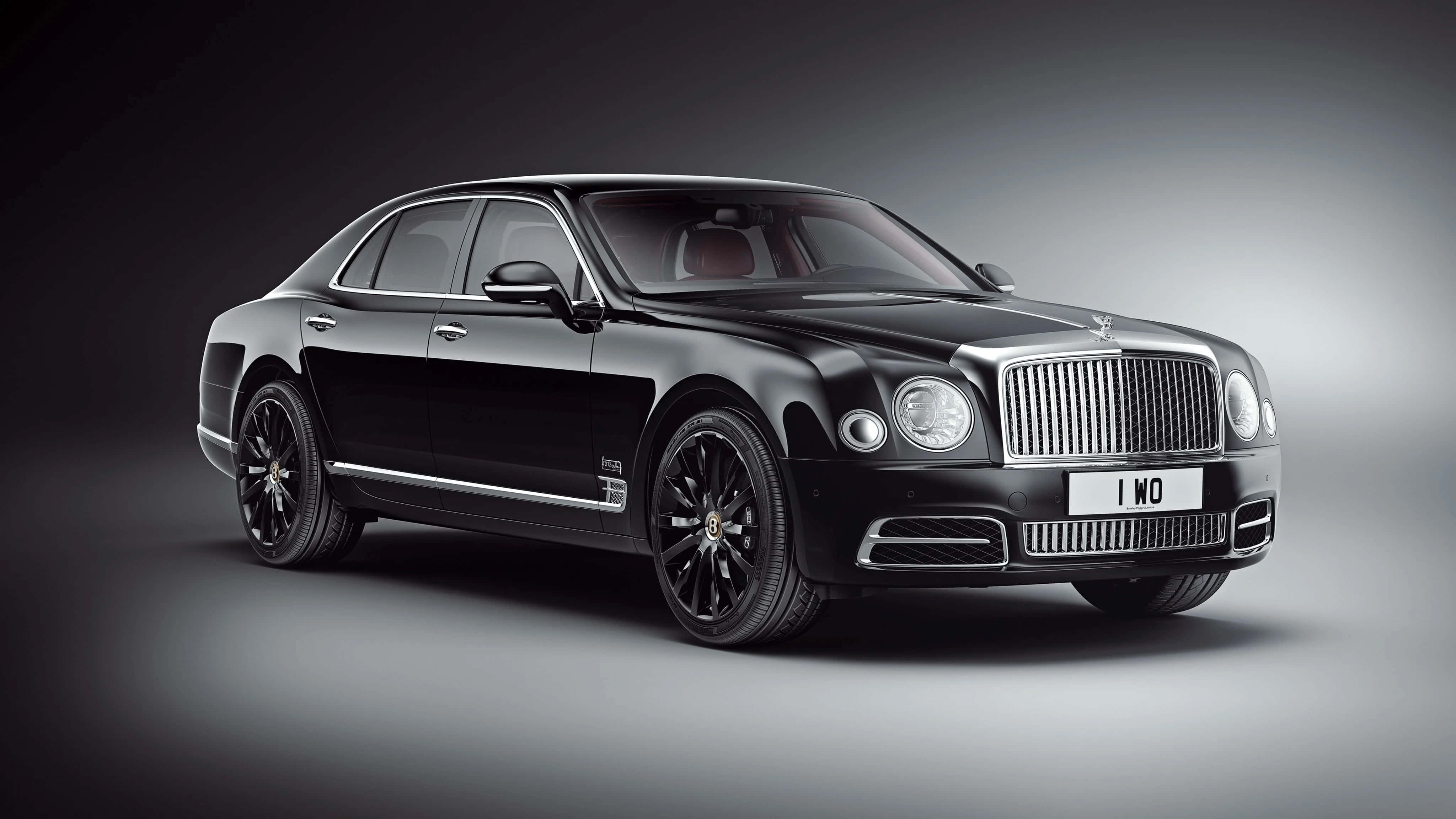Bentley Mulsanne 桌布 壁紙 — 一輛時尚的黑色賓利Mulsanne，帶有鍍鉻飾邊和自訂車牌，在漸變灰色工作室背景前靜止不動。