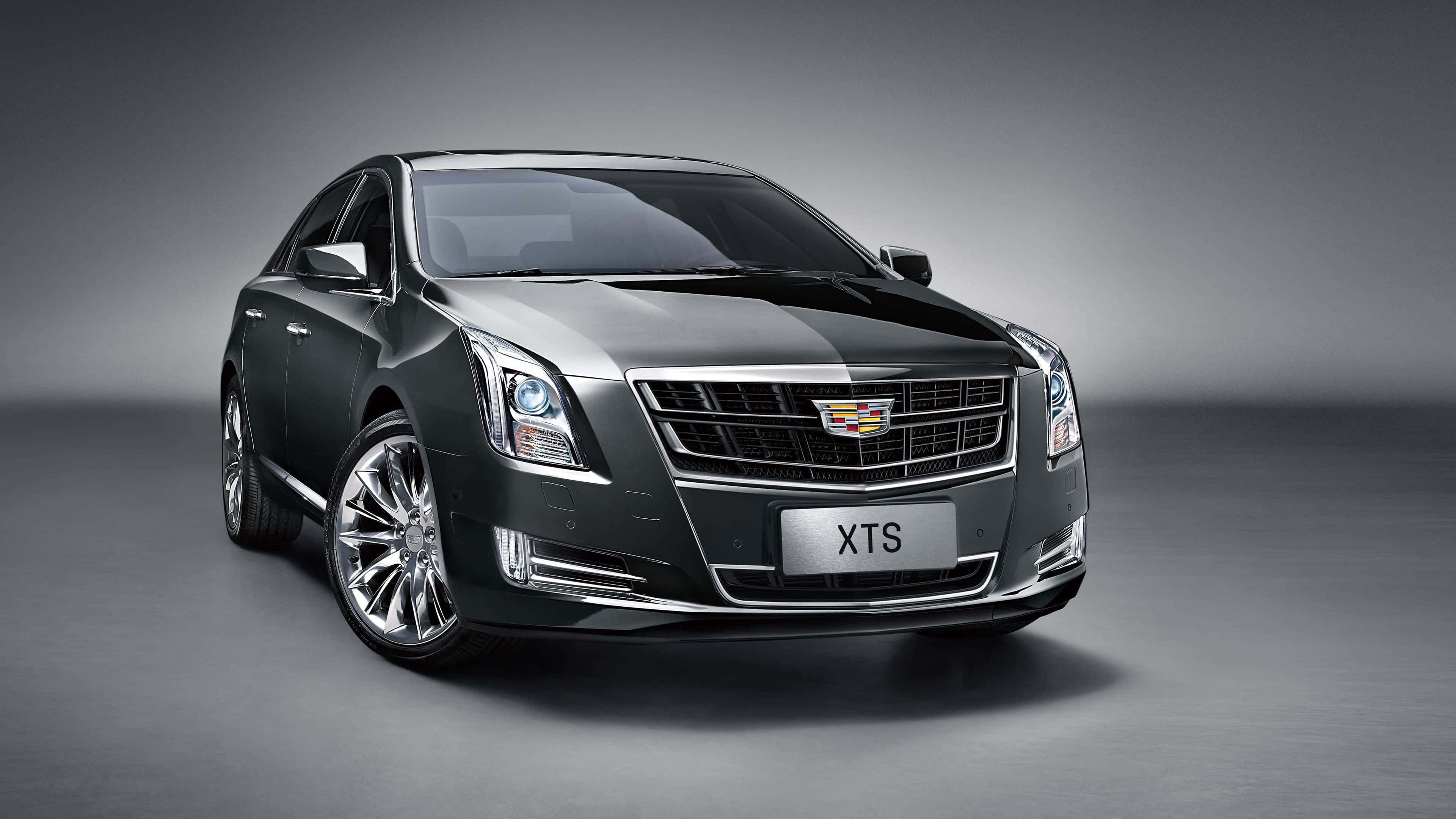 Cadillac Xts 桌布 壁紙 — 一輛時尚的黑色Cadillac XTS轎車在攝影棚燈光下閃耀，背景為簡約灰色。