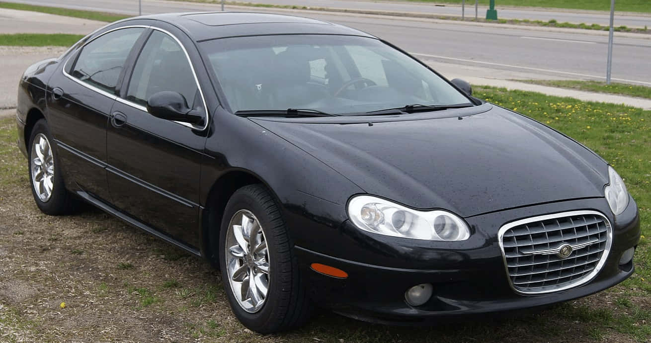 Chrysler Lhs 桌布 壁紙 — 一架時尚的黑色Chrysler房車停泊在路邊草地上，清晰可見其鍍鉻鬼面罩和合金輪圈。