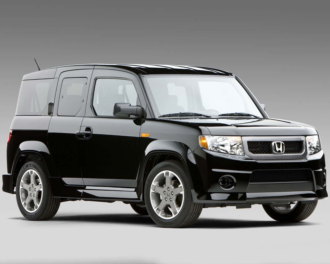 Honda Element 桌布 壁紙 — 一輛時尚的黑色本田Element SUV，在攝影棚燈光下展示，配備鉻合金輪轂和光澤表面。
