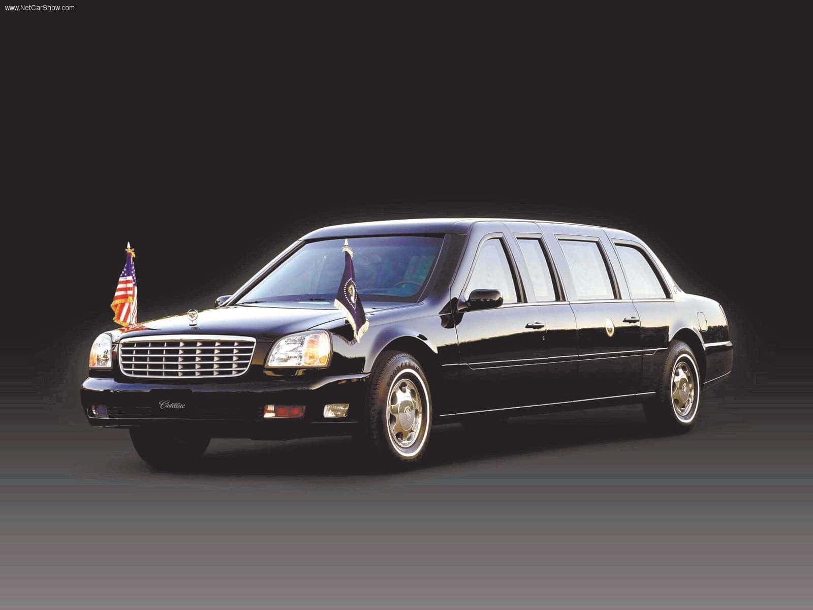 Cadillac Deville 桌布 壁紙 — 一輛時尚的黑色豪華轎車，帶有美國和總統旗幟，在黑暗的攝影棚背景下矗立。