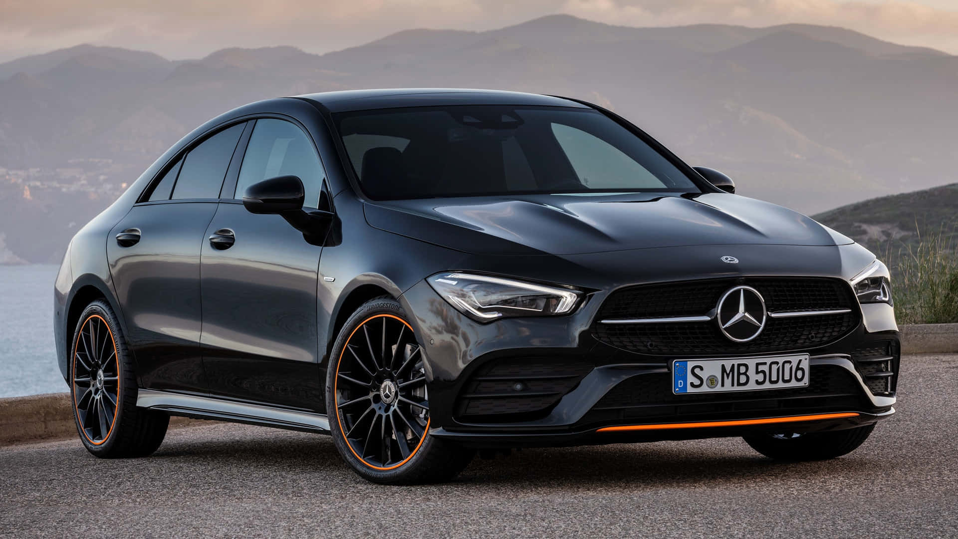 Mercedes Benz Cla-class 桌布 壁紙 — 一架型格黑色Mercedes-AMG CLA45 S停泊在海濱道路上，背景是山脈和海洋。