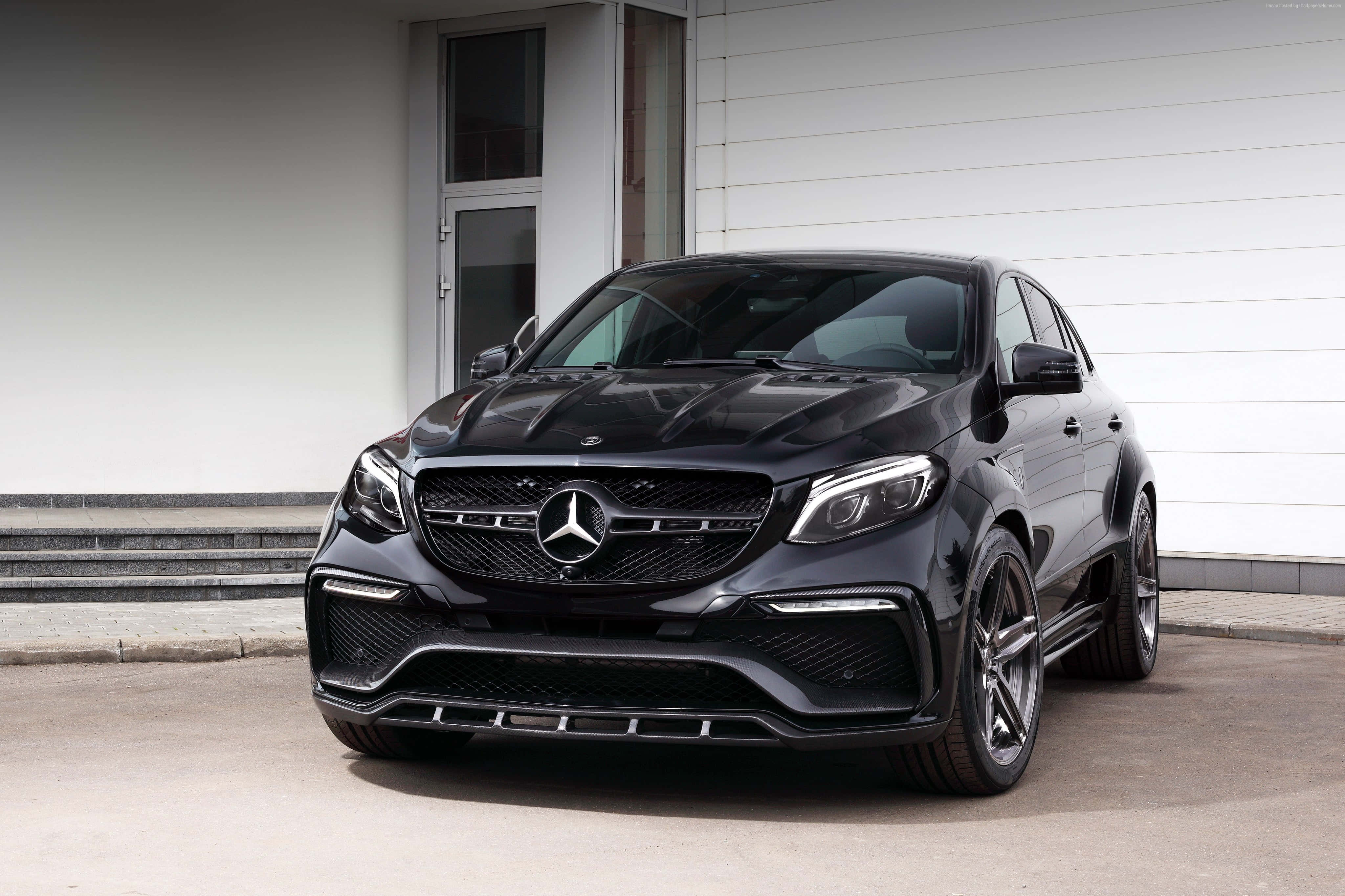 Mercedes Benz Gla-class 桌布 壁紙 — 一架時尚的黑色Mercedes-AMG GLE63 S Coupe停在一棟現代白色建築前，帶有灰色台階。