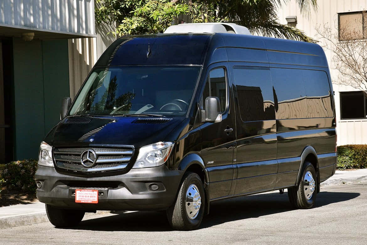 Mercedes Benz Sprinter 桌布 壁紙 — 一架時尚的黑色 Mercedes-Benz Sprinter 客貨車停泊在陽光明媚的街道上，背景有棕櫚樹和建築物。
