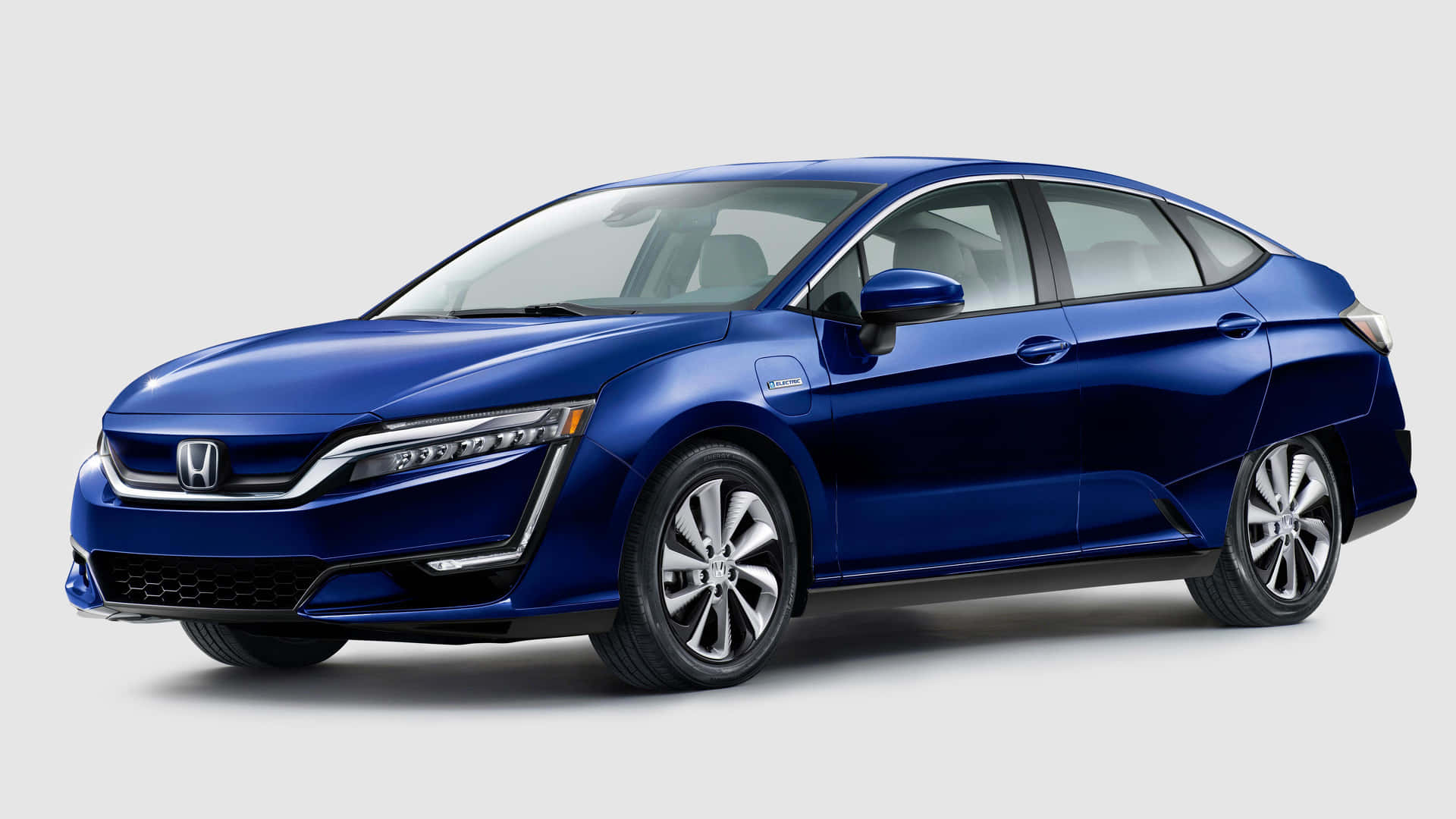 Honda Clarity 桌布 壁紙 — 一輛時尚的藍色本田Clarity插電式混合動力轎車，在工作室燈光下以潔白背景展示。