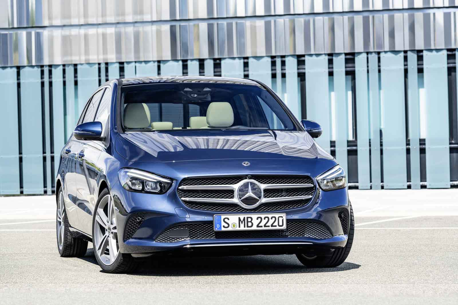 Mercedes Benz B-class 桌布 壁紙 — 一架時尚的藍色平治B-Class停泊在現代玻璃建築前，在明亮的日光下。