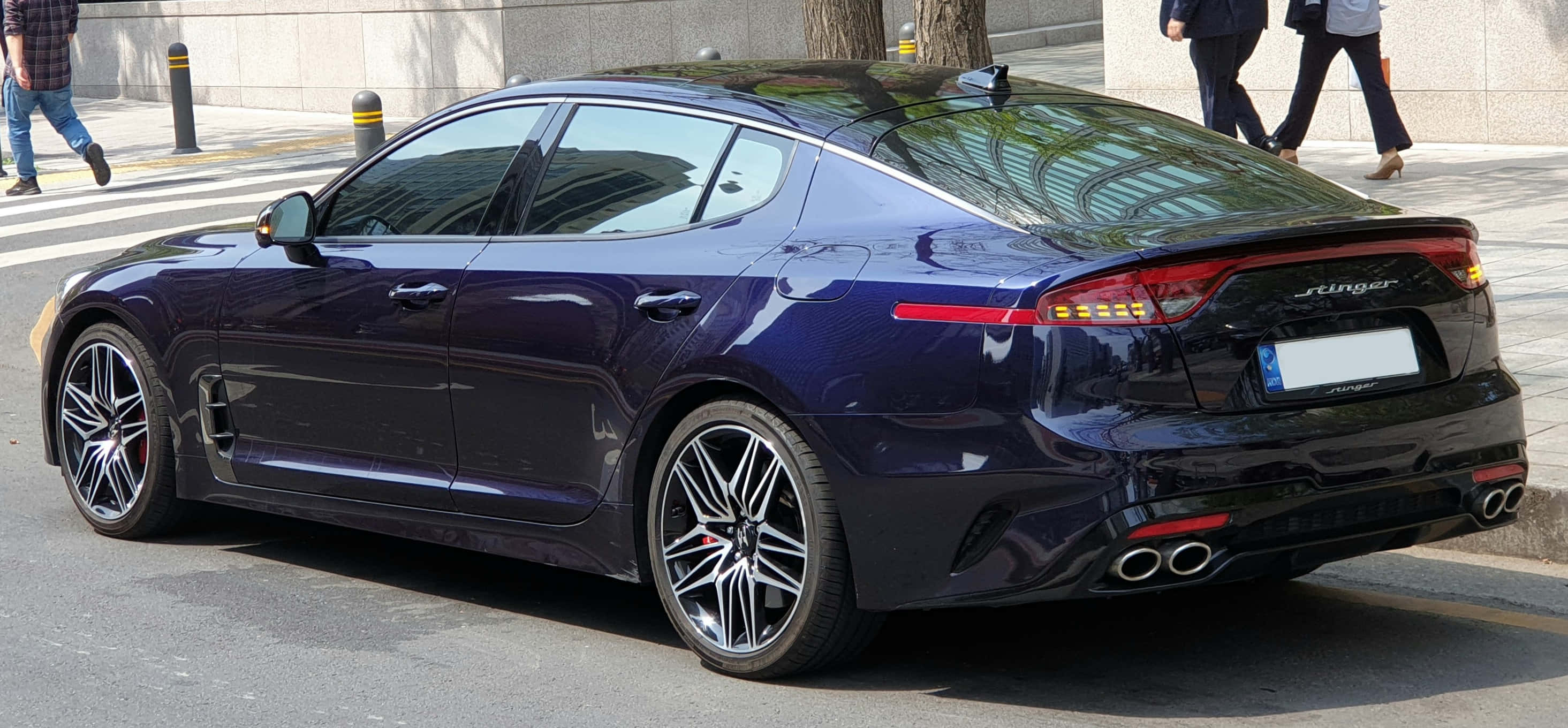 Kia Stinger 桌布 壁紙 — 一架時尚的深紫色Kia Stinger運動型轎車停泊在繁忙的街道上，有行人走過。