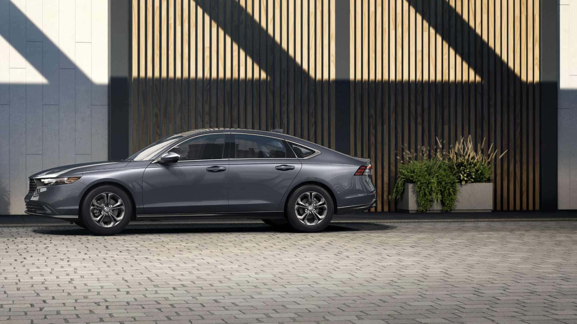 Honda Accord 桌布 壁紙 — 一輛時尚的灰色轎車停在鵝卵石路面上，旁邊是帶有幾何陰影的現代木條牆。