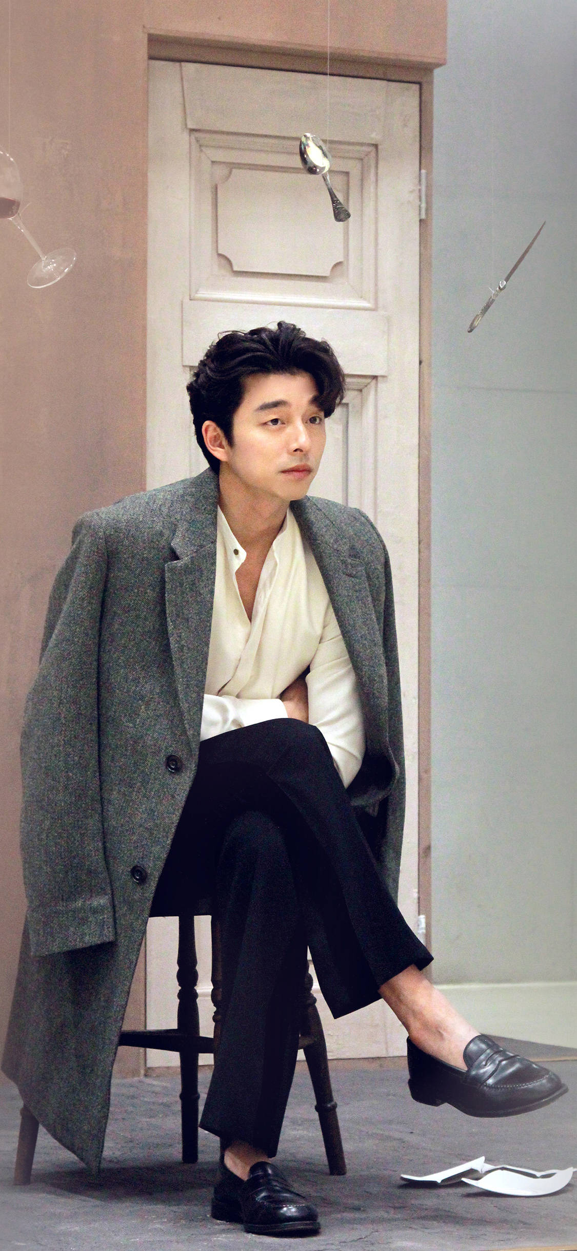 Actors 桌布 壁紙 — 一位穿著灰色外套的時尚男士坐在凳子上，背景是柔和的牆壁，漂浮的酒杯和刀。