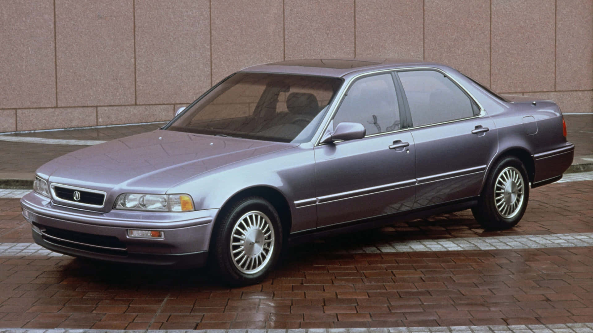 Acura Legend 桌布 壁紙 — 一架時尚嘅銀色Acura房車泊喺濕嘅磚砌路面，背景係米色瓷磚牆。